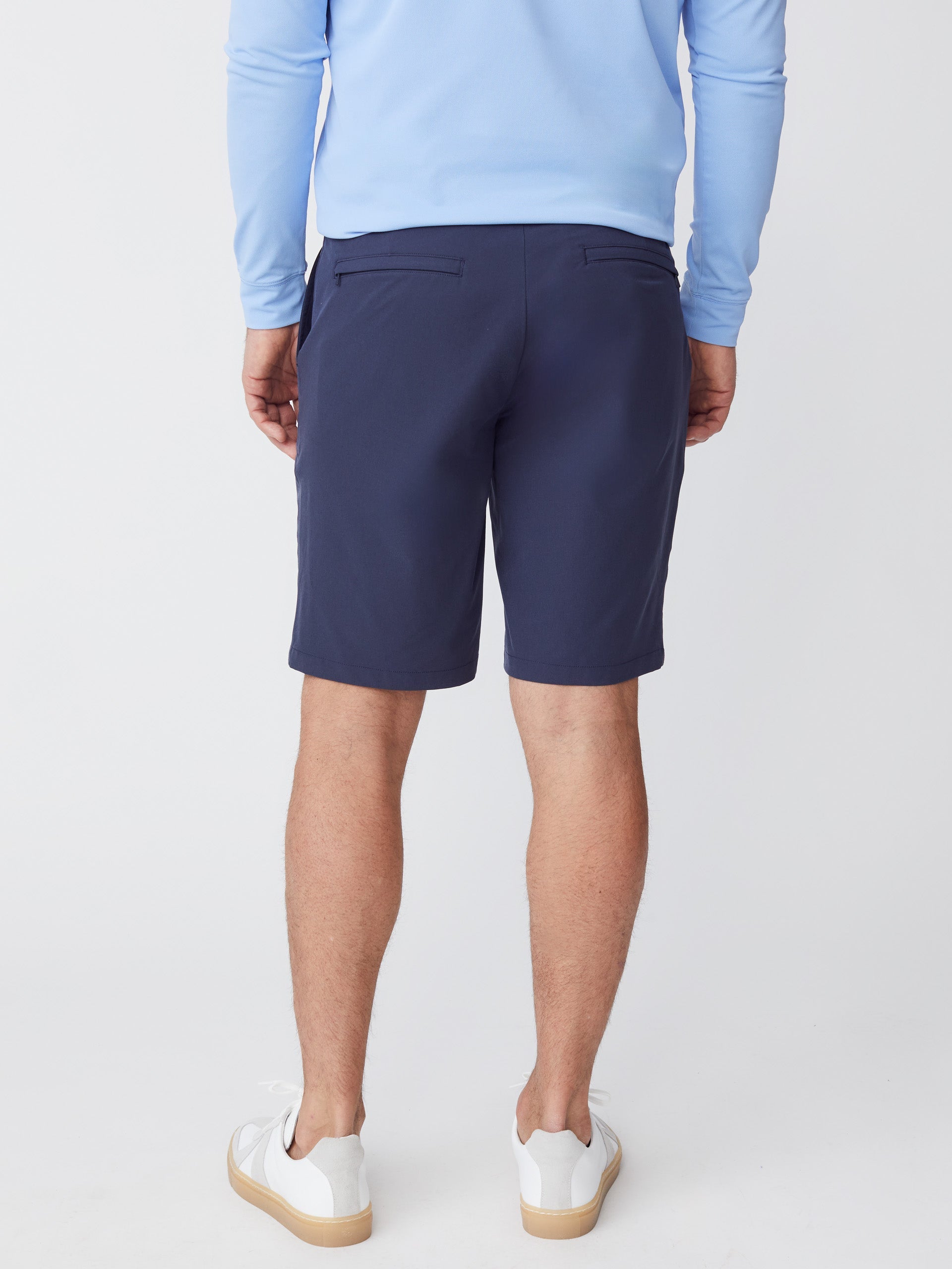 Model wearing J.McLaughlin Silas shorts in navy made with performance fabric.