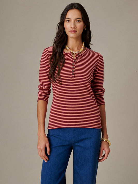 Woman wearing a Sinclair Henley in Stripe by J.McLaughlin, featuring a classic long-sleeve striped shirt paired with casual blue pants, reflecting timeless style and quality.