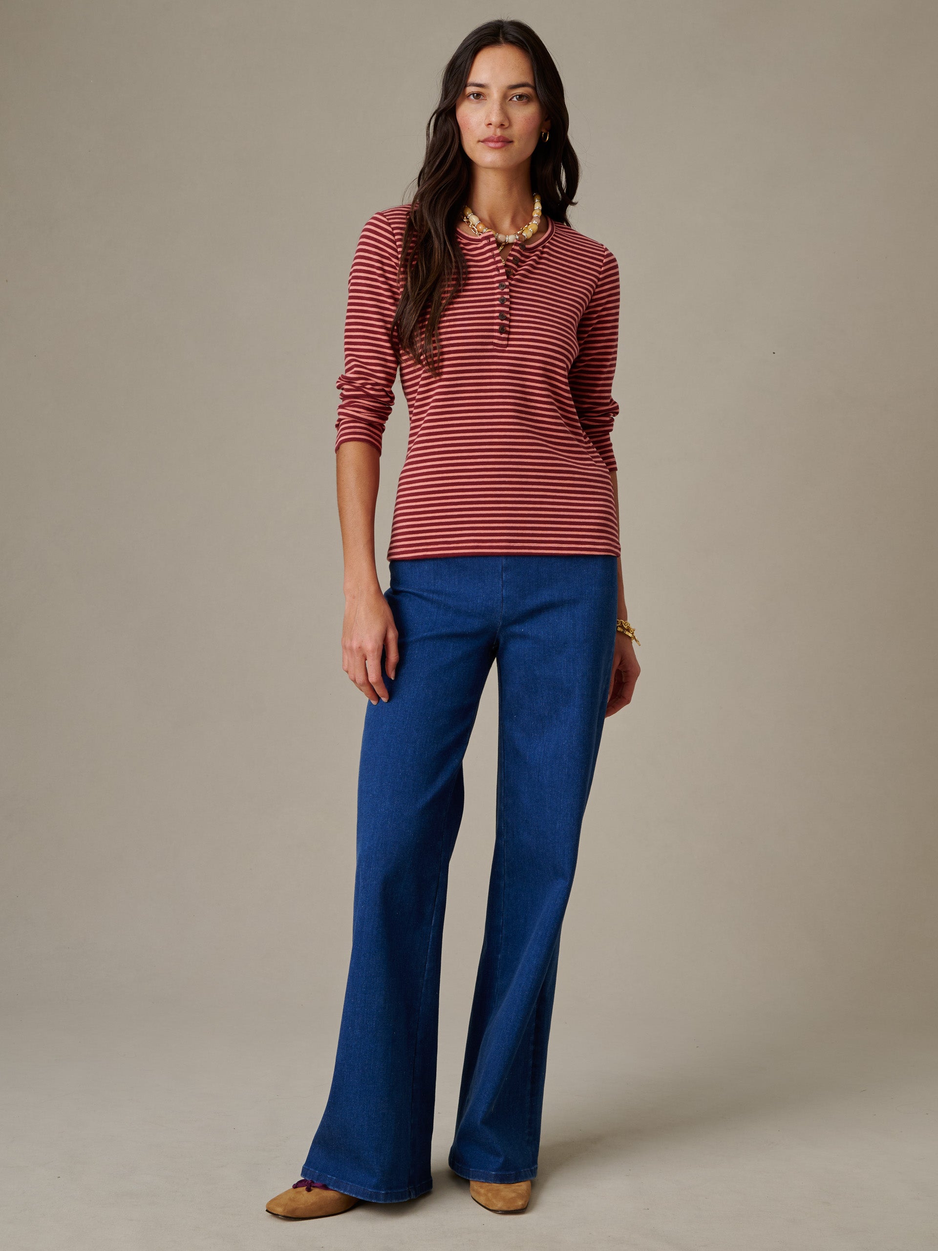 Woman wearing Sinclair Henley in Stripe by J.McLaughlin paired with blue wide-leg pants, showcasing a timeless, effortlessly stylish top with enduring design and thoughtful craftsmanship.