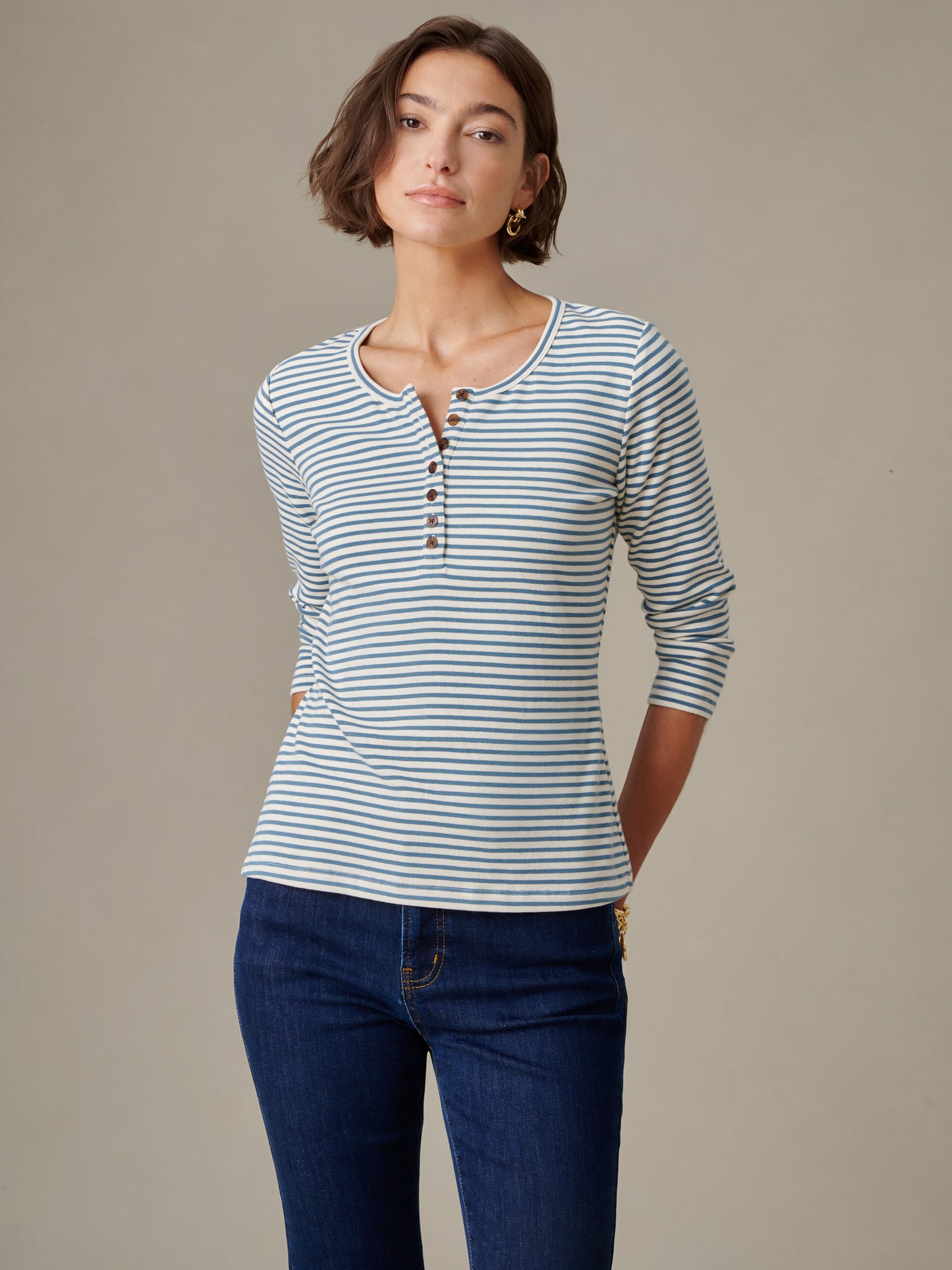 Woman wearing Sinclair Henley in Stripe long-sleeve top paired with dark jeans, showcasing J.McLaughlin’s effortlessly stylish and enduring designs in classic stripes.