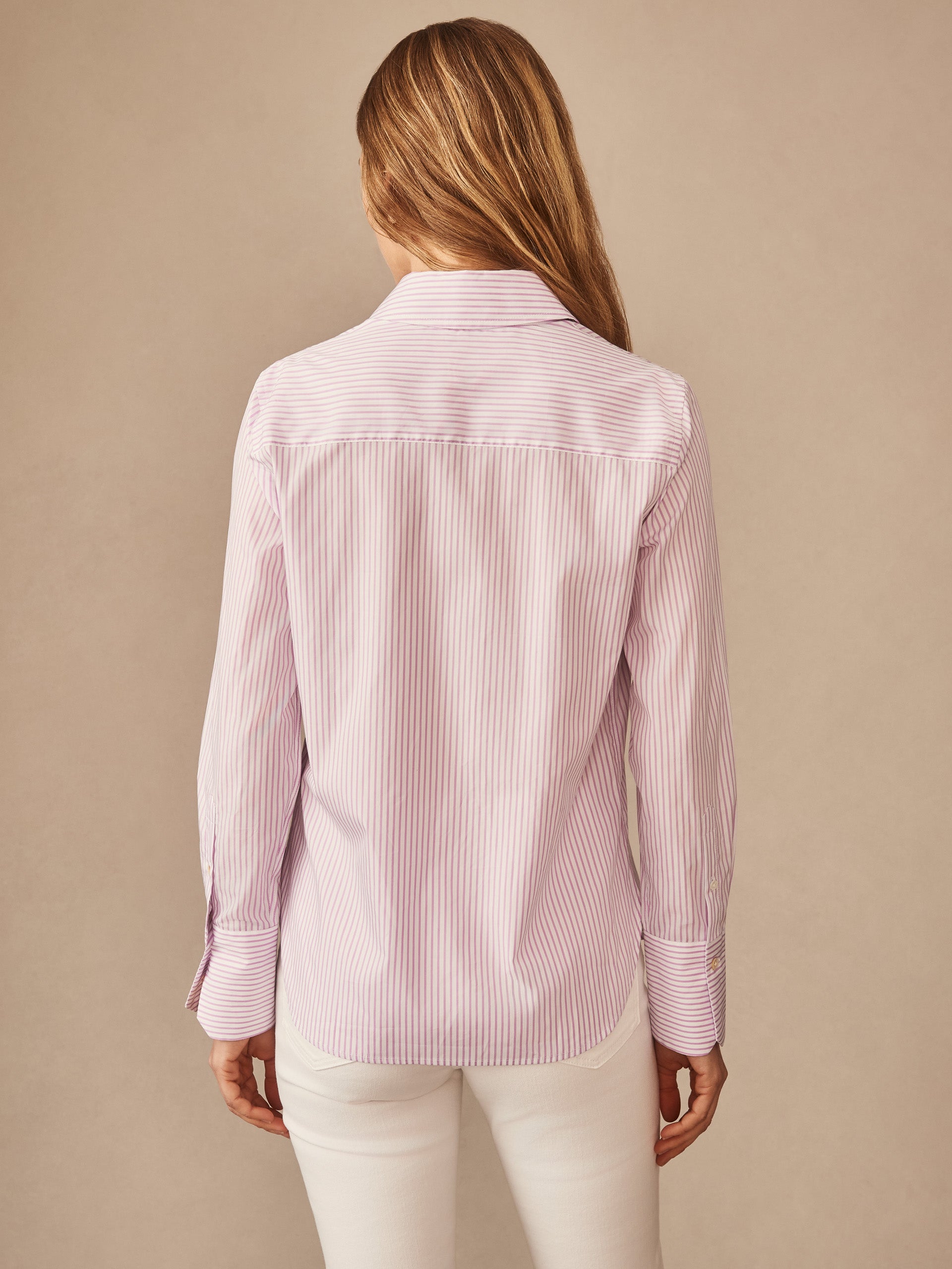 Back view of a woman wearing the Sloane Shirt in Stripe by J.McLaughlin, featuring soft lavender and white stripes in an effortlessly stylish, enduring design, a destination for defining style. Life, Well-Lived.