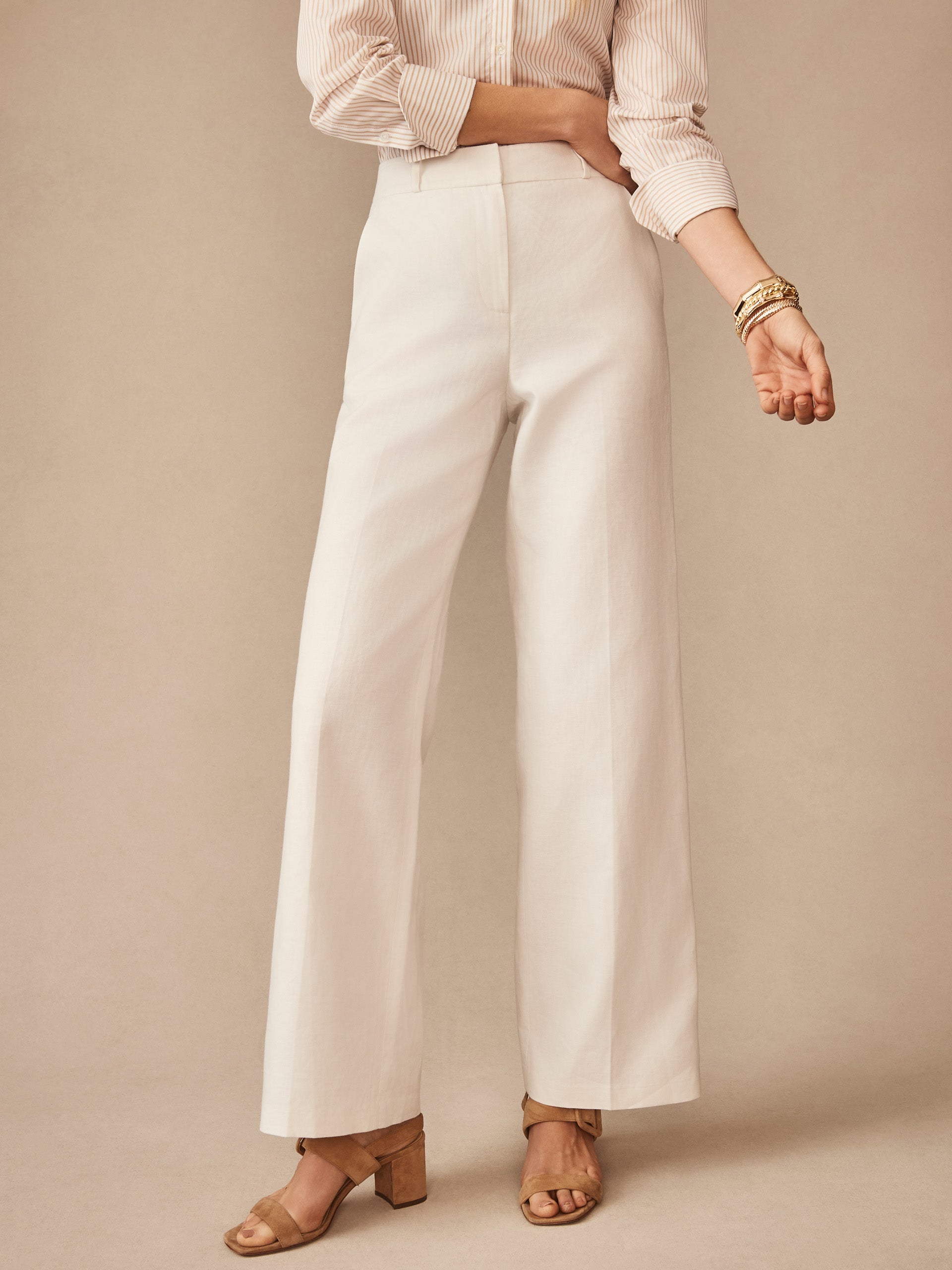 Woman wearing J.McLaughlin Blythe Linen Blend Pants in a neutral tone paired with a striped blouse and tan heeled sandals, showcasing effortlessly stylish, enduring designs with innovative fabrics.