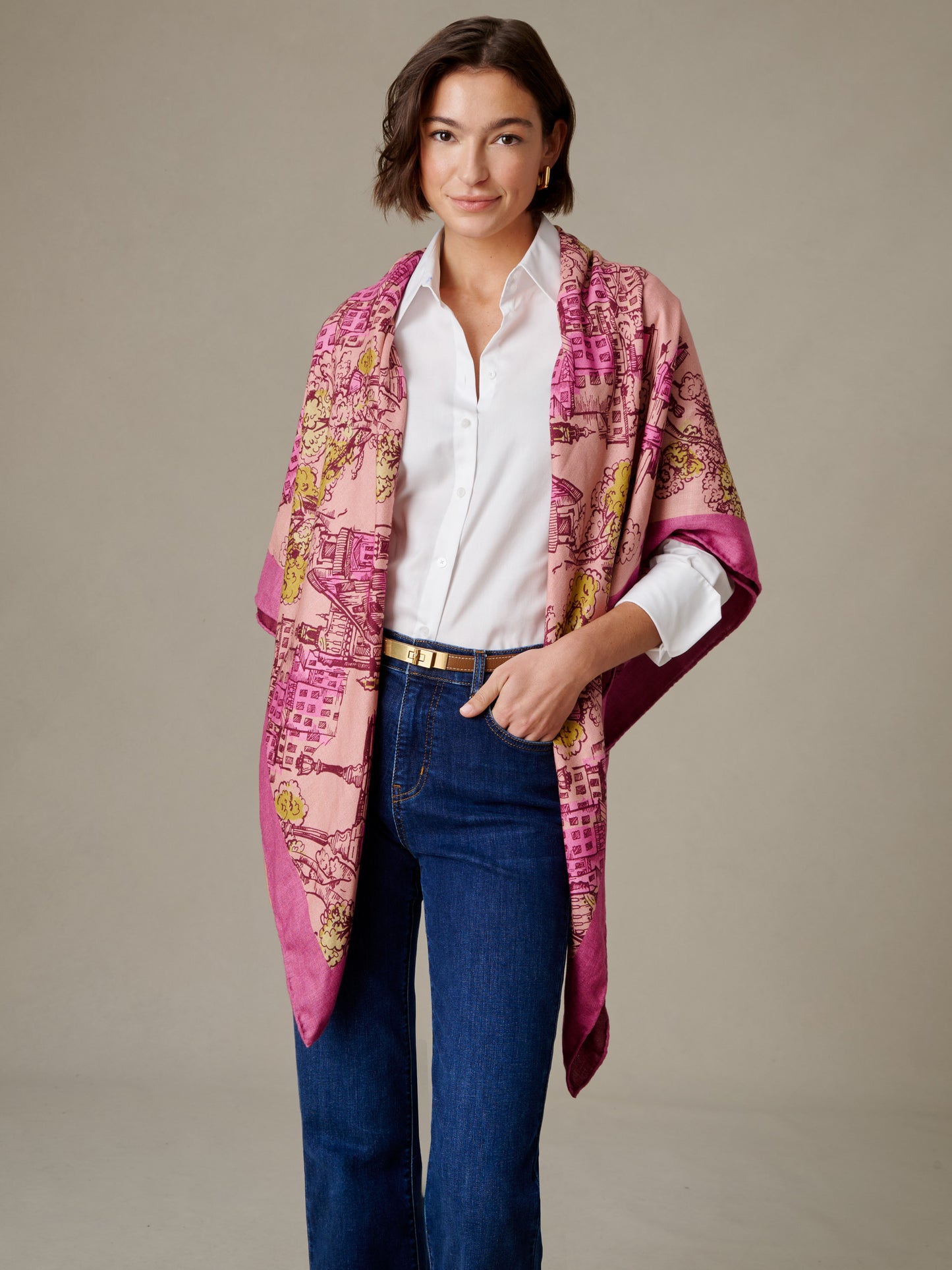 The Charlotte Scarf in Boulevard Sketch Border draped on a woman over a white shirt and jeans in a pink patterned design