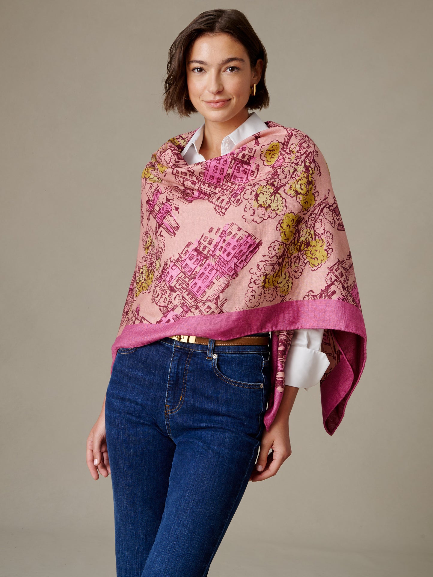 The Charlotte Scarf in Boulevard Sketch Border by J.McLaughlin draped over a woman in a white blouse and jeans with a pink floral motif and border