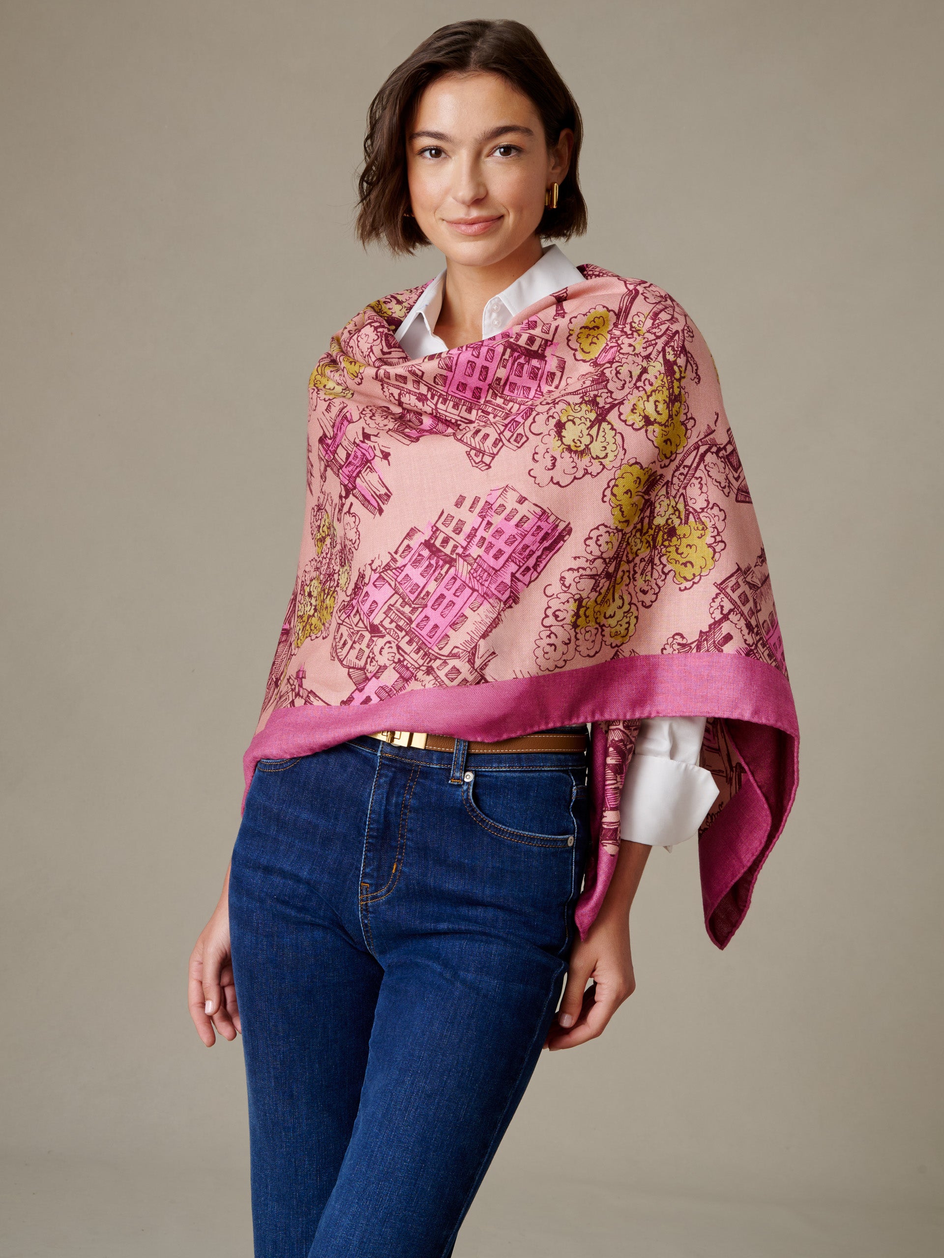 The Charlotte Scarf in Boulevard Sketch Border by J.McLaughlin draped over a woman in a white blouse and jeans with a pink floral motif and border