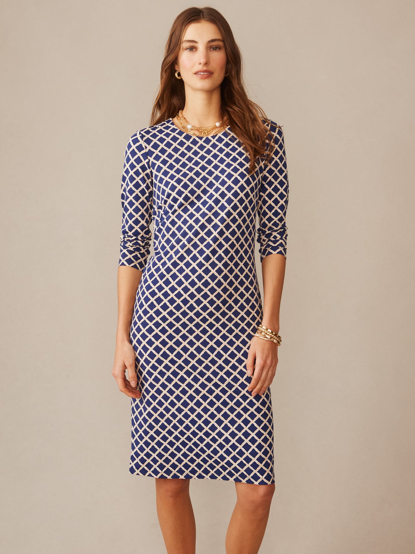 A model wears the Sophia Dress in Micro Bamboo by J.McLaughlin, featuring a navy and sand geometric pattern, showcasing effortlessly stylish, enduring designs with innovative fabrics from a destination for defining style. Life, Well-Lived.