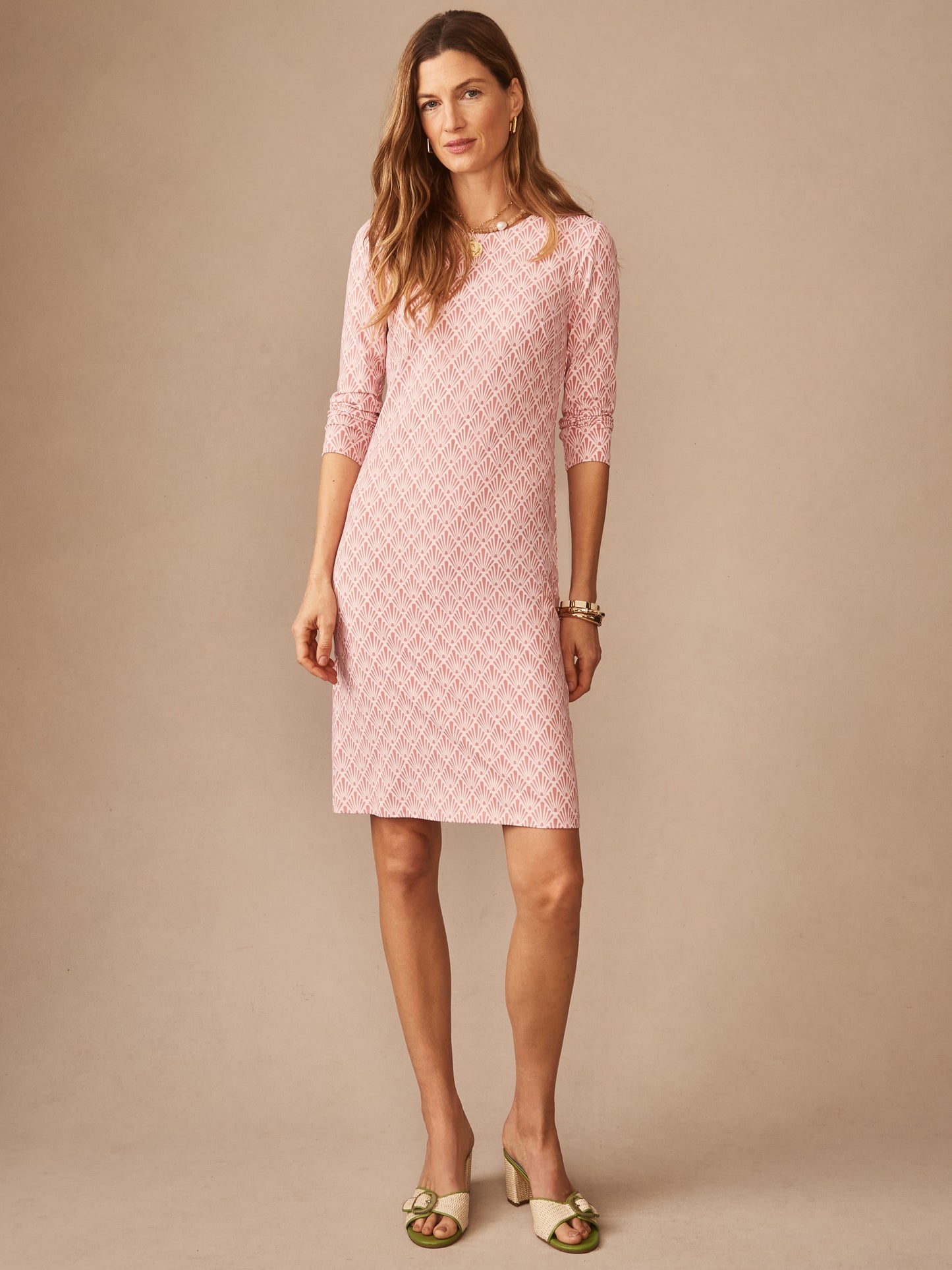 A woman wearing the Sophia Dress in Sandshell by J.McLaughlin, featuring a soft pink textured pattern and three-quarter sleeves, embodying effortlessly stylish, enduring designs and innovative fabrics. A destination for defining style. Life, Well-Lived.