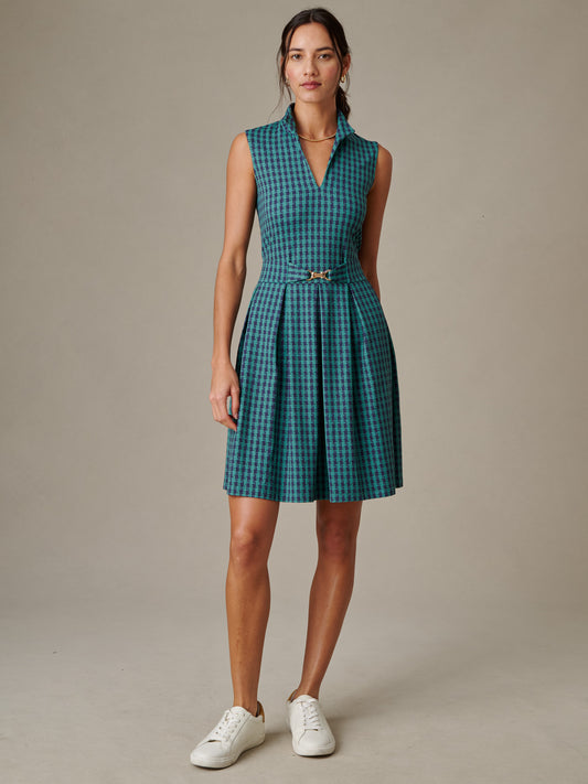 Woman wearing a sleeveless Steffi Dress in Algiers Check by J.McLaughlin, featuring a fitted waist and pleated skirt, styled with casual white sneakers.