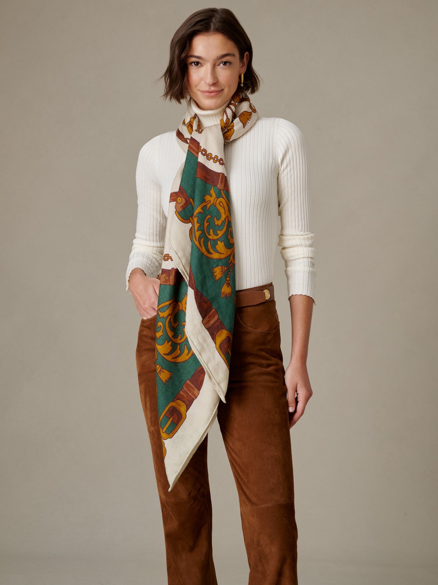 The Charlotte Scarf in Gilded Bridle Border by J.McLaughlin draped around a model in a soft cashmere silk blend with a classic patterned design