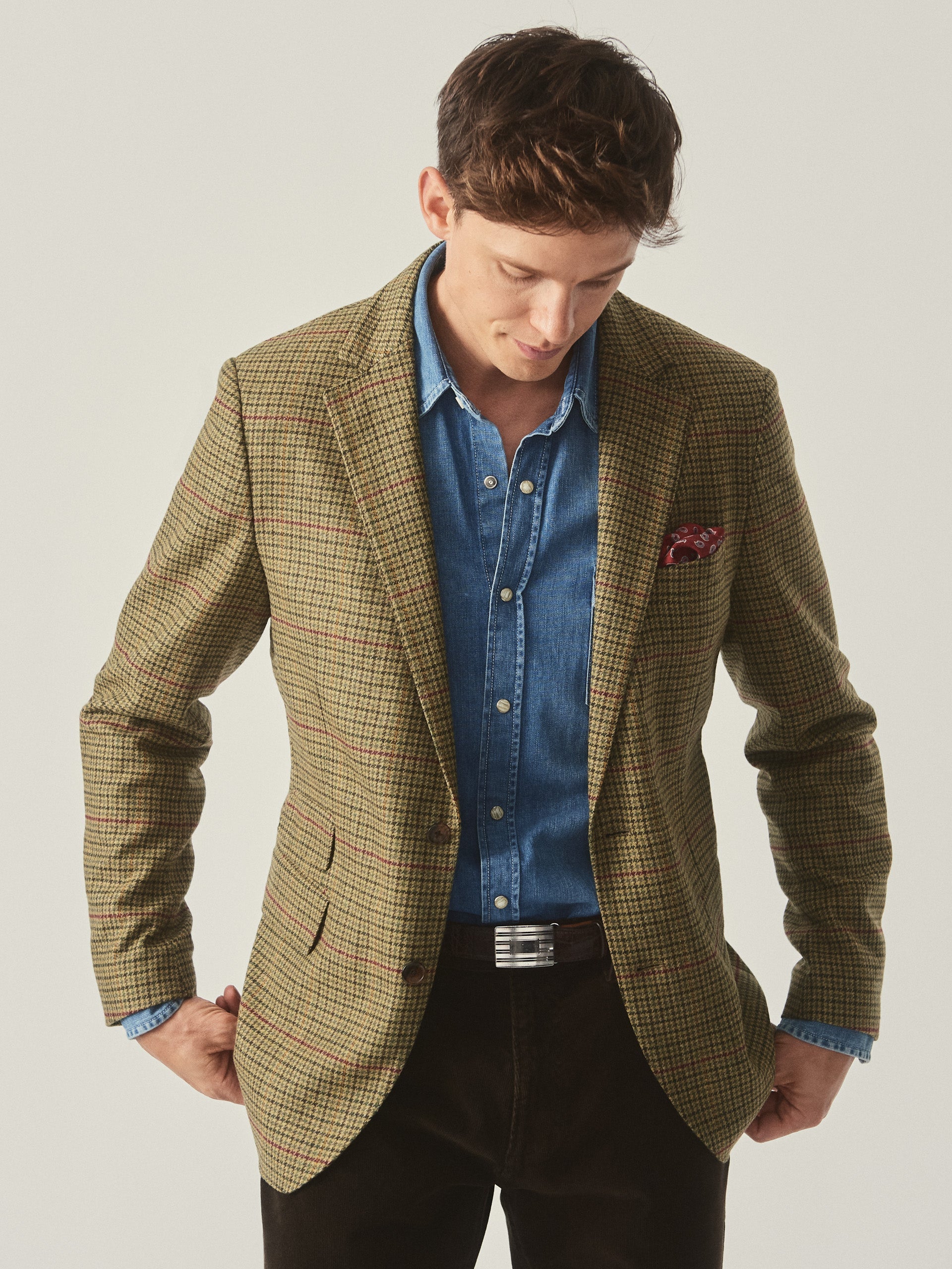 Model wearing J.McLaughlin Suffolk blazer in brown/green/red/mustard made with wool.