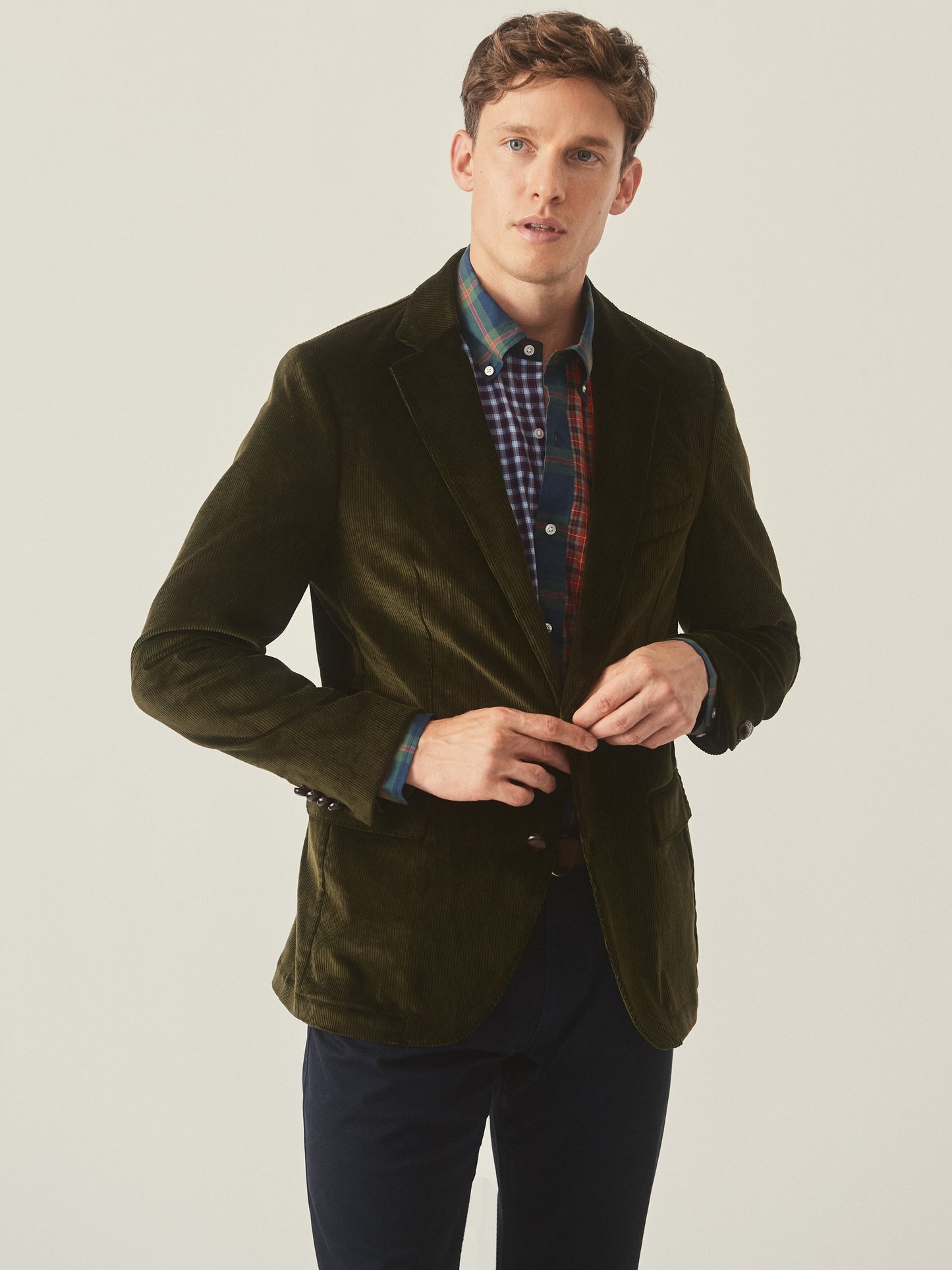 Model wearing J.McLaughlin Suffolk blazer in dark olive made with cotton corduroy.