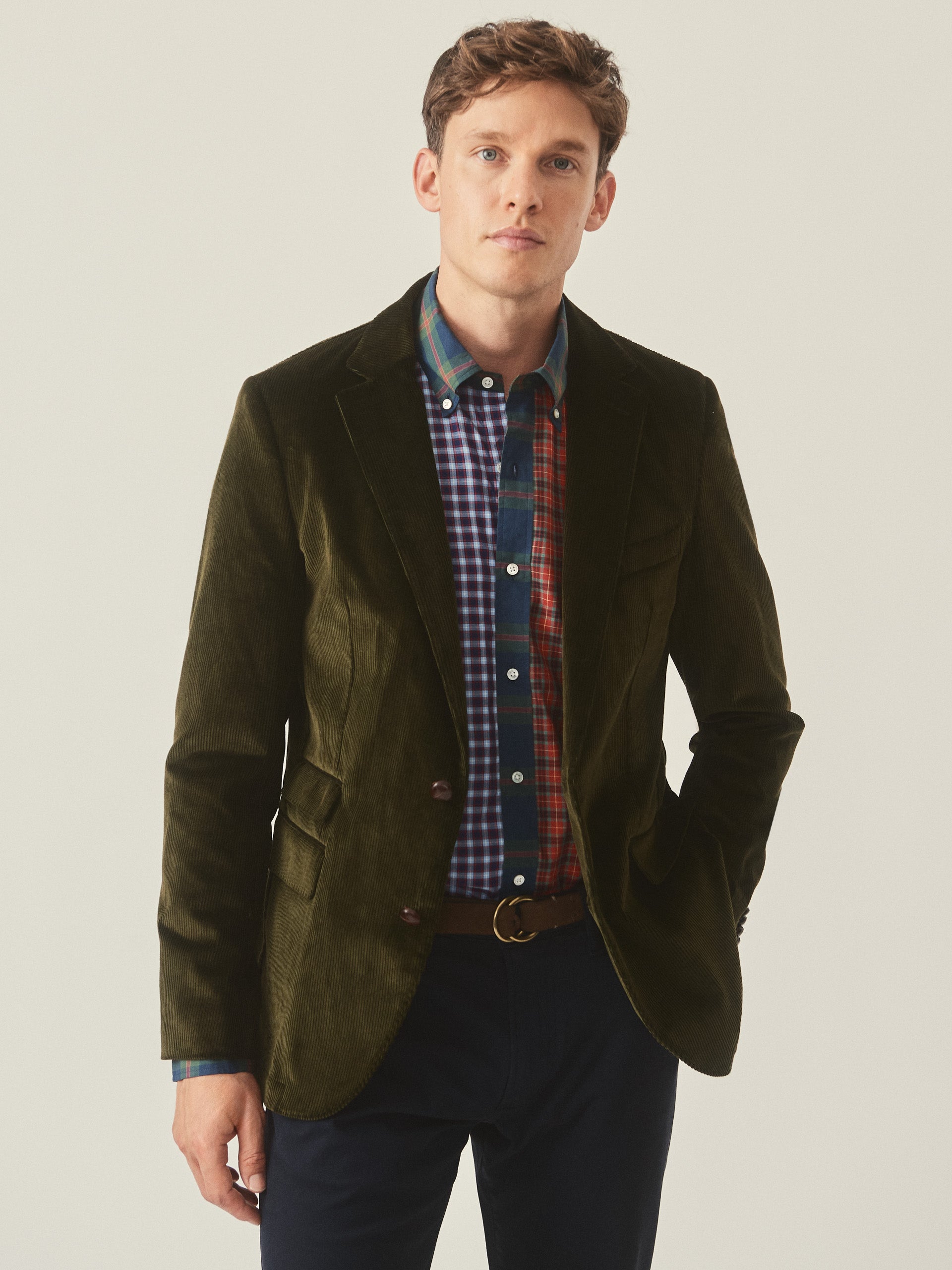 Model wearing J.McLaughlin Suffolk blazer in dark olive made with cotton corduroy.