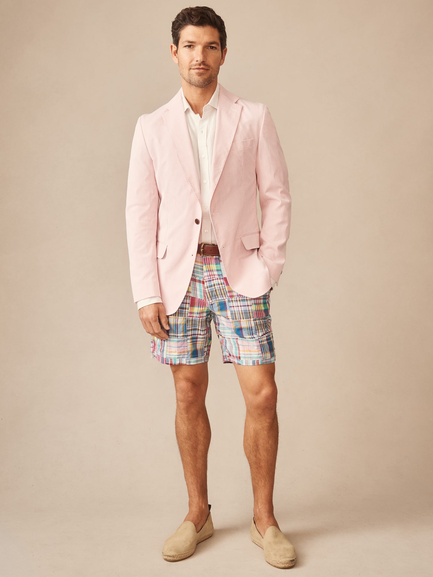 A man models the Suffolk Sport Coat in Fineline by J.McLaughlin, paired with colorful shorts and loafers, showcasing effortlessly stylish, enduring designs in innovative fabrics.