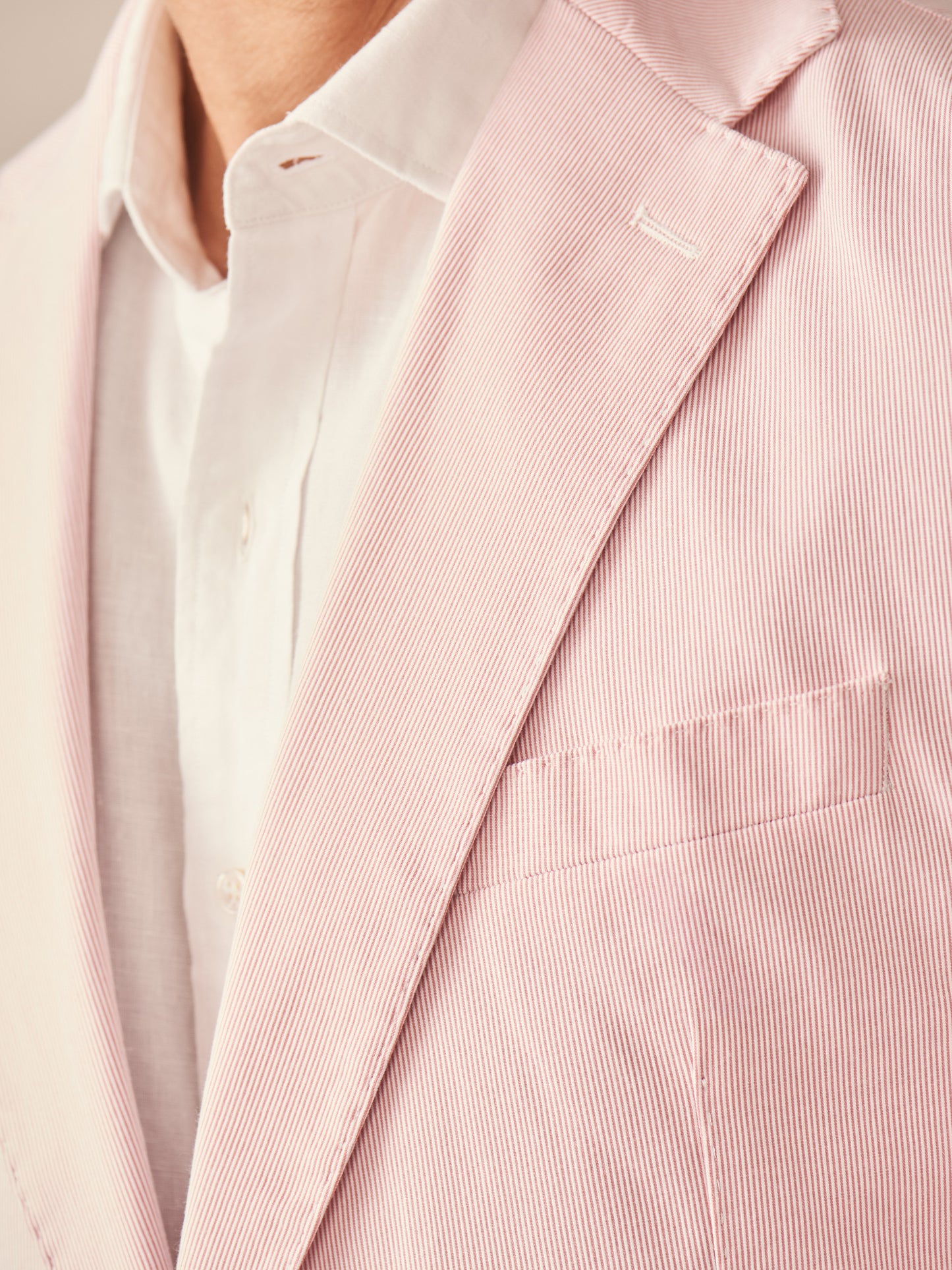 Close-up of a finely detailed Suffolk Sport Coat in Fineline by J.McLaughlin, showcasing its subtle pink and white stripes, crafted with innovative fabrics for enduring designs and timeless style.