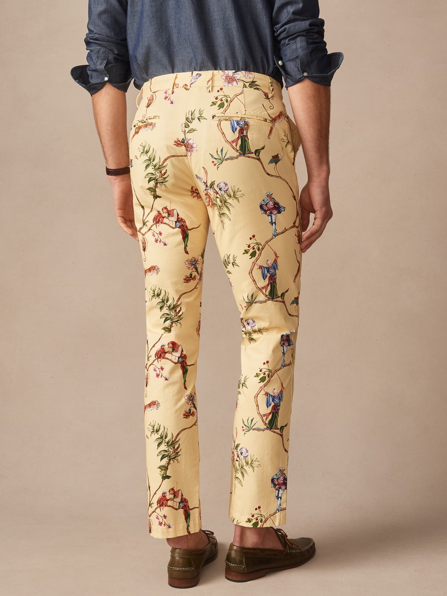 Man wearing Madison Fancy Pants in Garden Spectacle by J.McLaughlin, featuring intricate garden-themed print on tailored pants paired with a dark shirt and brown shoes, embodying effortlessly stylish, enduring designs with a legacy of timeless fashion. A destination for defining style. Life, Well-Lived.