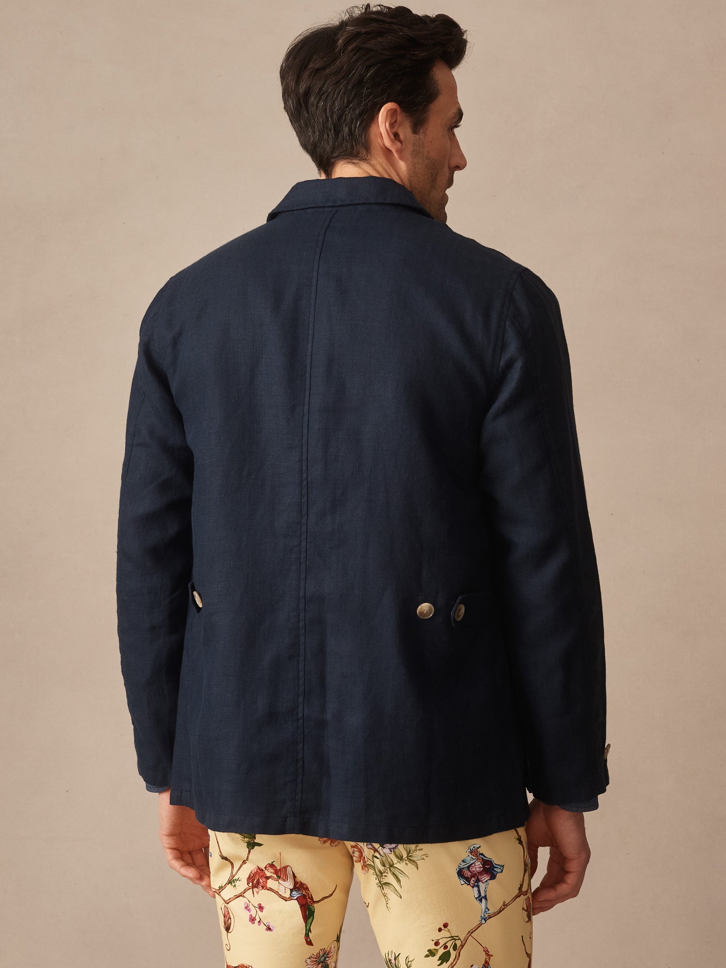 Man wearing a navy Aston Linen Safari Jacket by J.McLaughlin, showcasing effortlessly stylish, enduring designs with innovative fabrics in a legacy of timeless fashion. A destination for defining style. Life, Well-Lived.