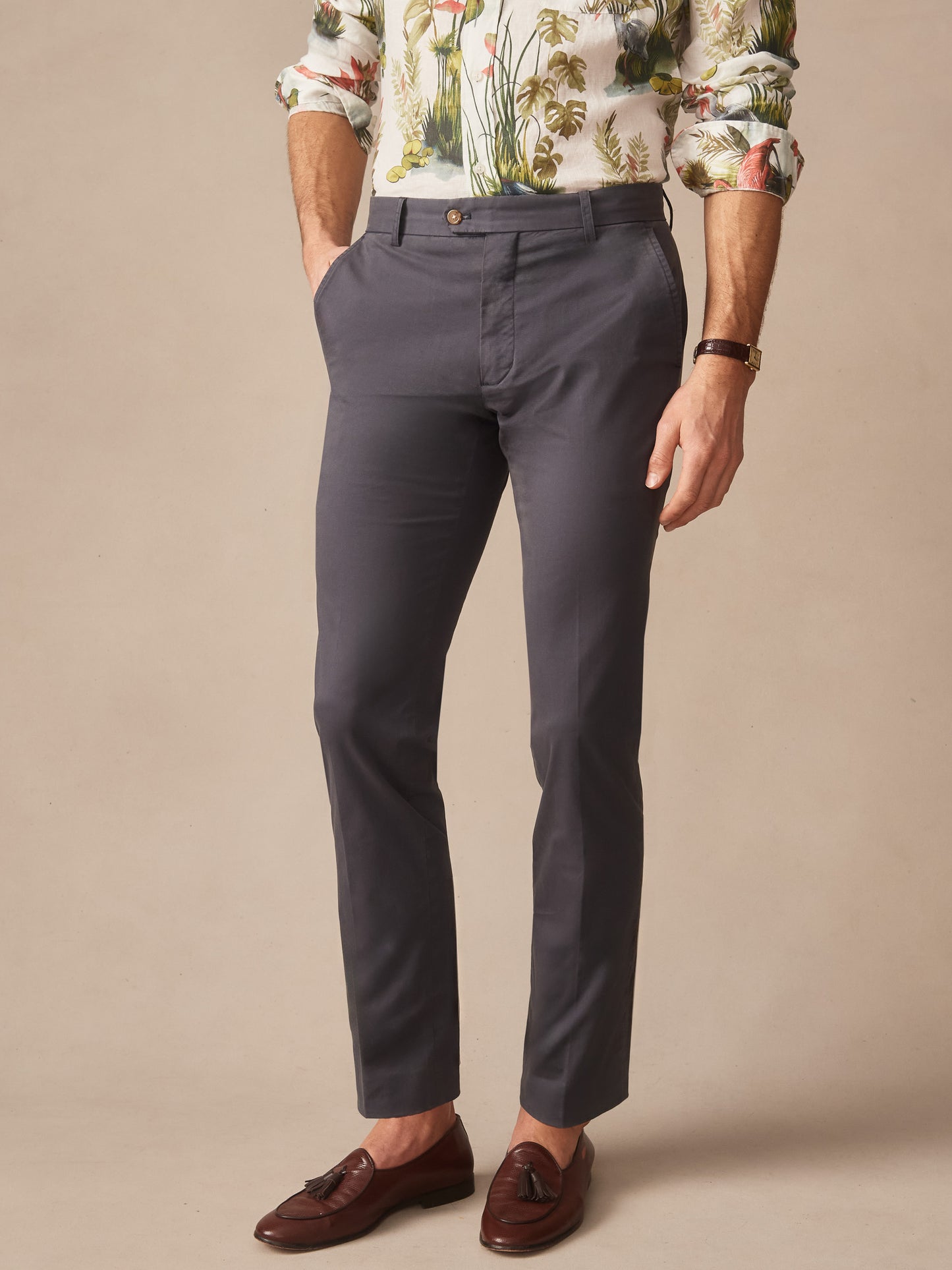 Man wearing washed black Madison Pants by J.McLaughlin paired with a floral shirt and brown tassel loafers, showcasing effortlessly stylish, enduring designs crafted with innovative fabrics.