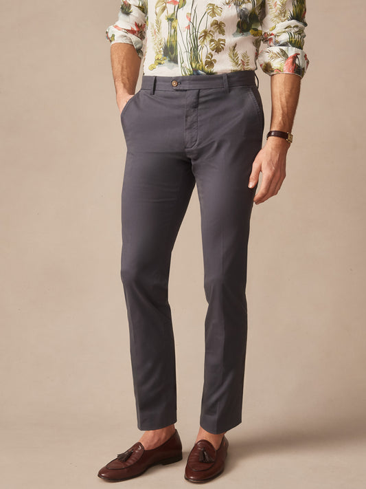 Man wearing washed black Madison Pants by J.McLaughlin paired with a floral shirt and brown tassel loafers, showcasing effortlessly stylish, enduring designs crafted with innovative fabrics.