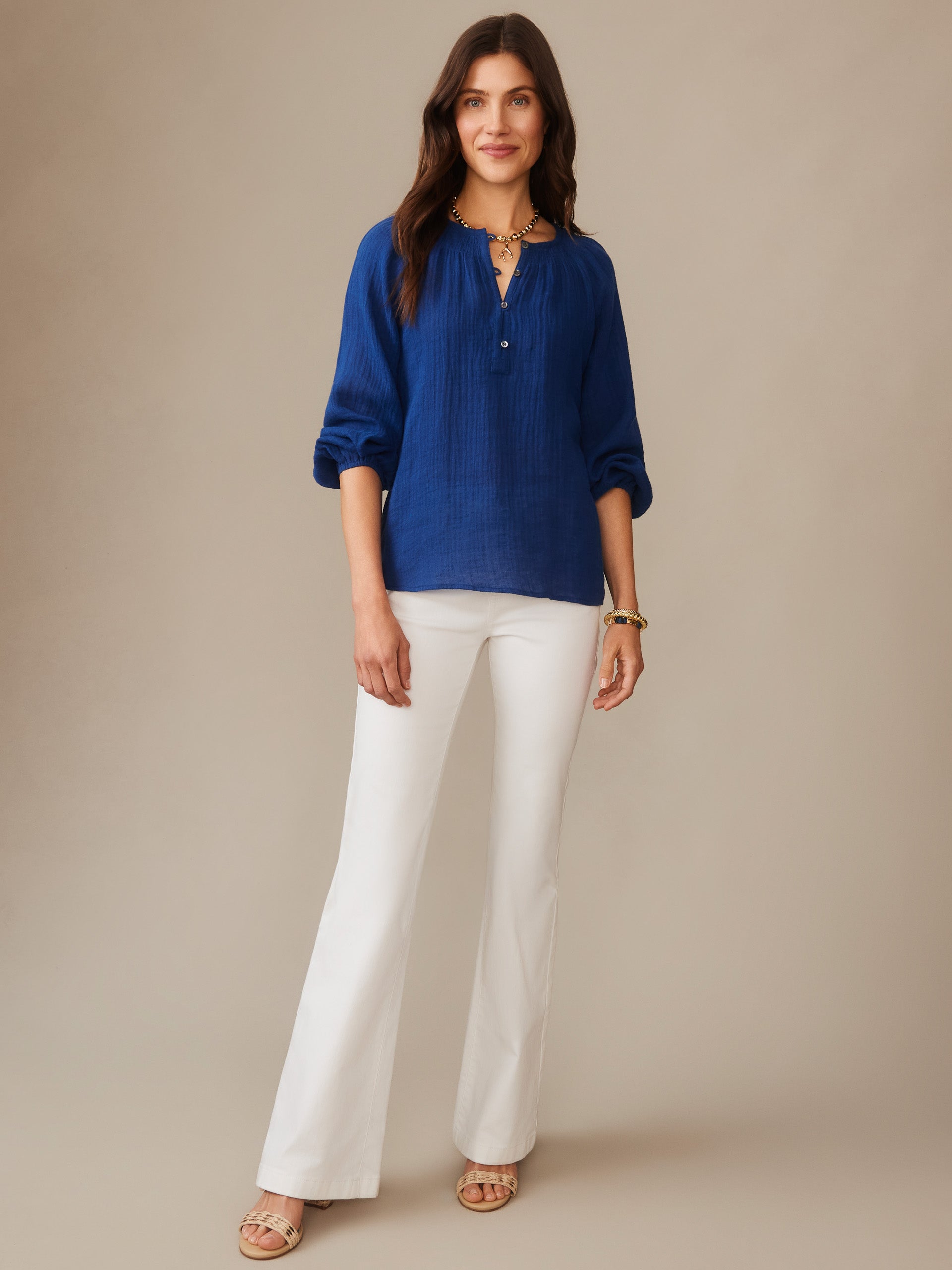 Woman wearing a nautical navy Tatiana Linen Blouse by J.McLaughlin paired with white pants, showcasing effortlessly stylish, enduring designs in innovative fabrics.