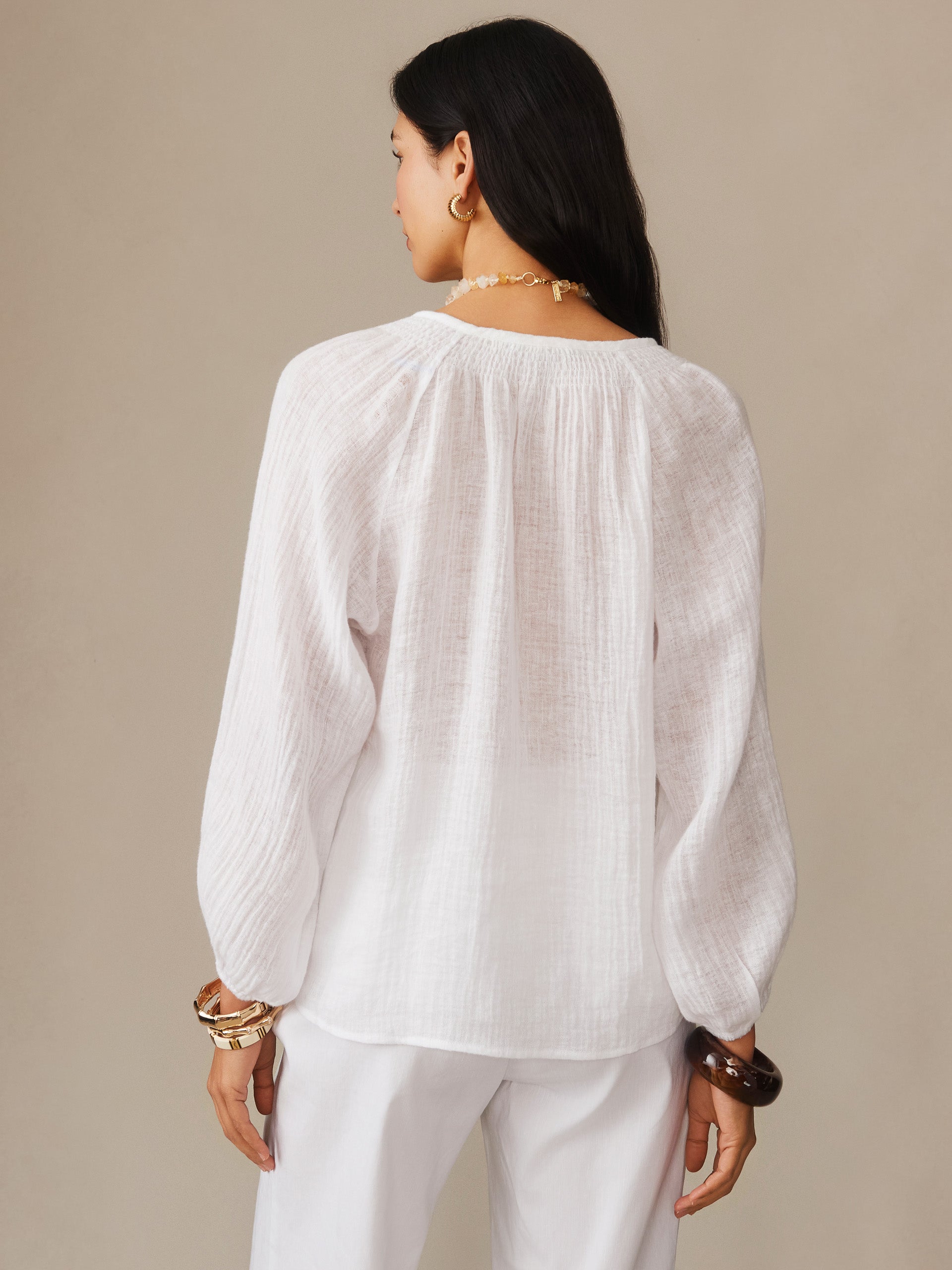 Model wearing the Tatiana Linen Blouse by J.McLaughlin, featuring lightweight white fabric and relaxed fit, embodying effortlessly stylish, enduring designs with a legacy of timeless fashion.
