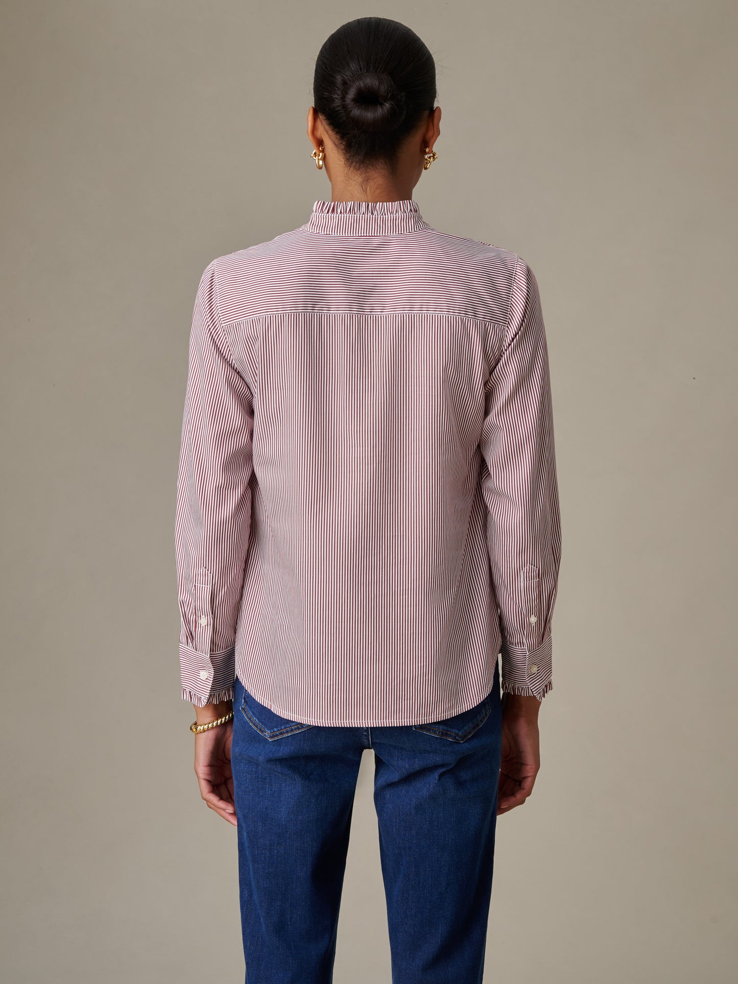 Woman wearing the Tess Ruffle Collar Shirt in Stripe by J.McLaughlin, showcasing the back with fine vertical stripes and a ruffled collar in a timeless classic style.