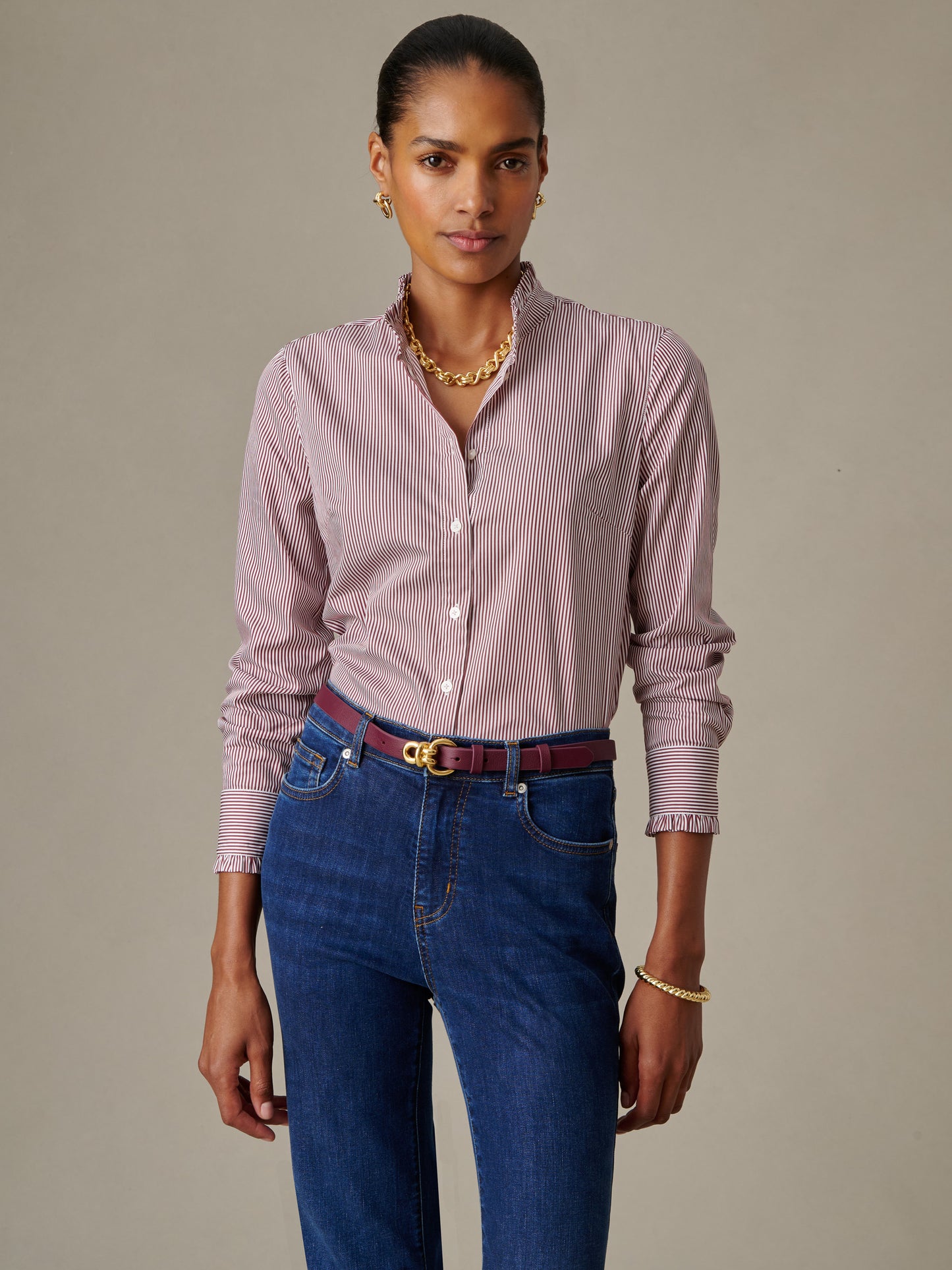 Woman wearing a Tess Ruffle Collar Shirt in Stripe by J.McLaughlin, styled with classic jeans and accessories, showcasing an effortlessly stylish look with enduring designs.
