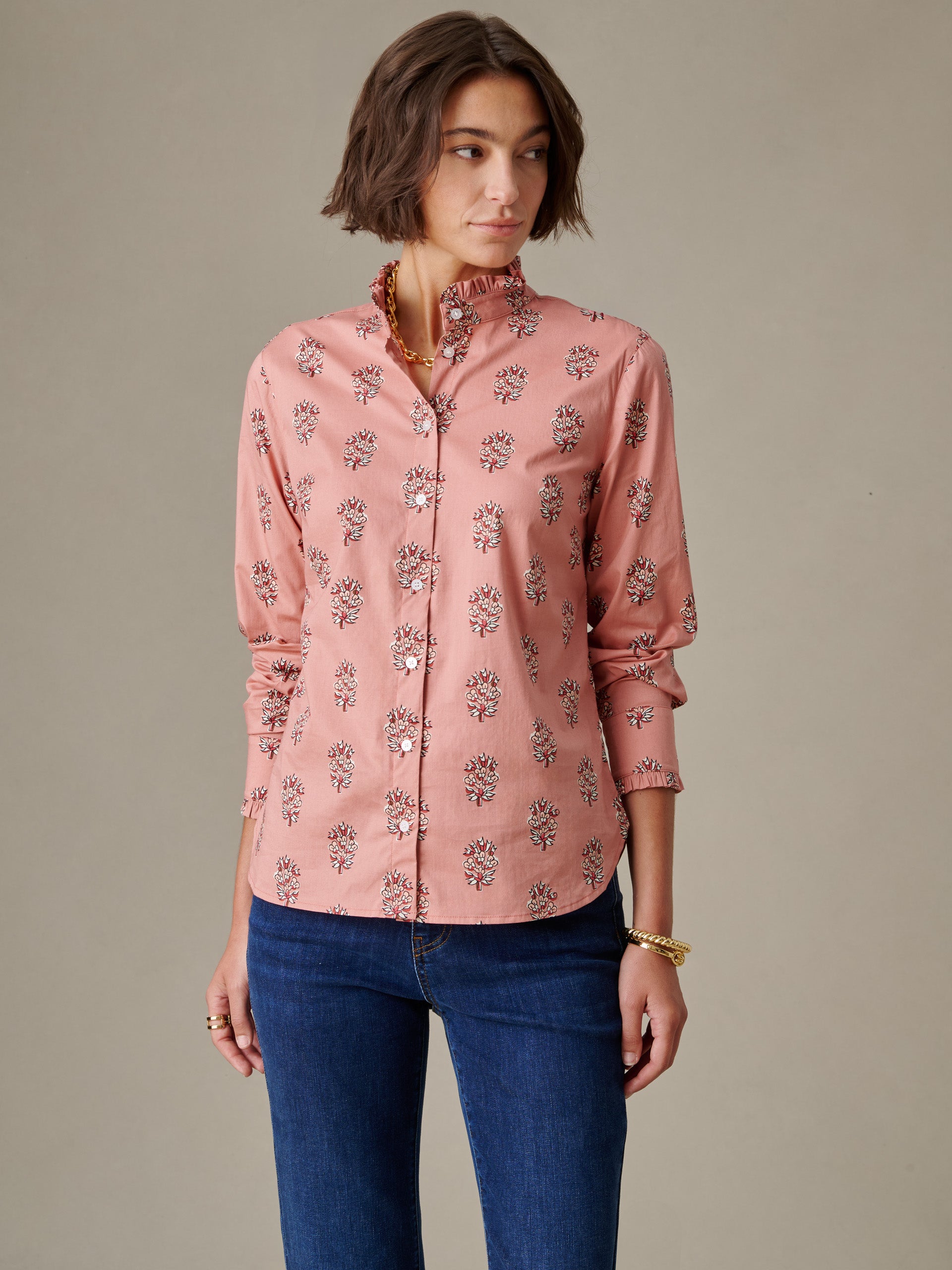 Woman wearing a pink Tess Ruffle Collar Shirt in Heritage Bloom with floral pattern and ruffled collar, paired with blue jeans, styled by J.McLaughlin for effortless style and timeless appeal.