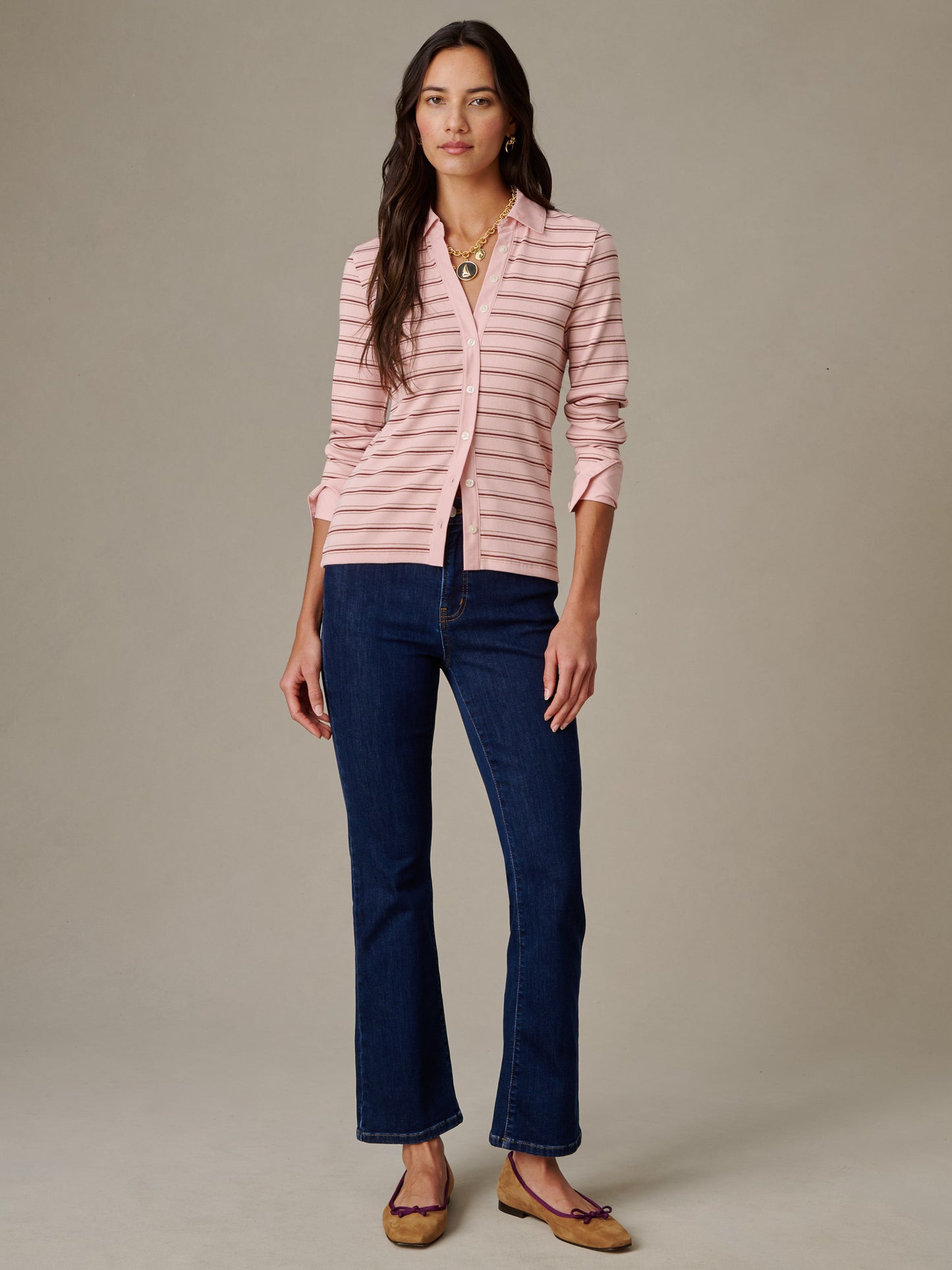 Woman wearing Theodora Shirt in Stripe, a lightweight pink striped shirt from J.McLaughlin, paired with dark blue jeans and tan flats, showcasing effortlessly stylish casual wear.