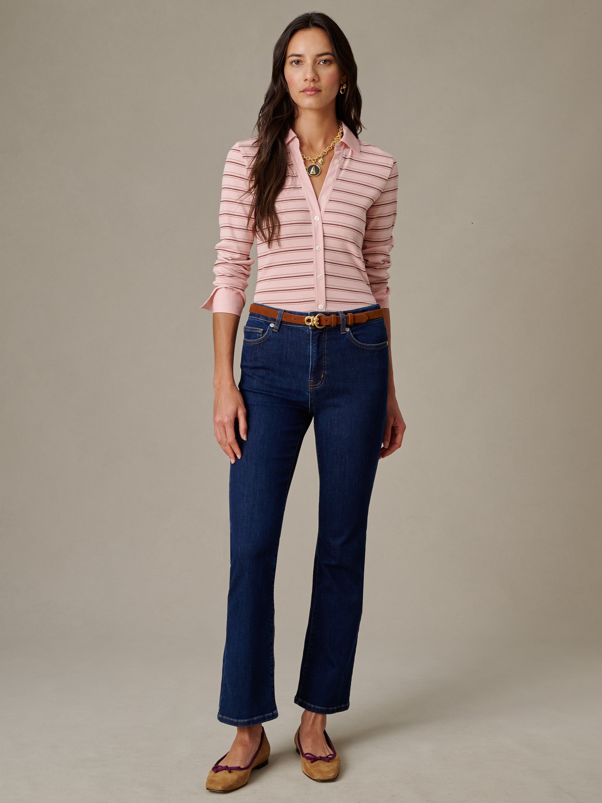 Woman wearing Theodora Shirt in Stripe by J.McLaughlin paired with dark blue jeans and brown belt, showcasing effortlessly stylish and enduring designs.