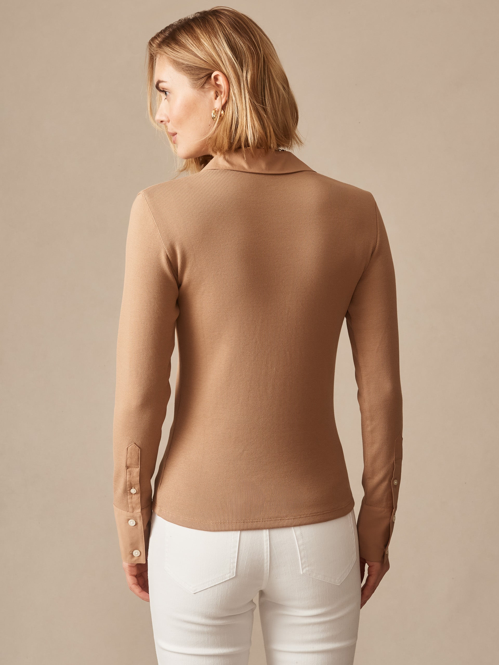 Woman wearing Theodora Shirt in a warm cinnamon tone by J.McLaughlin, showcasing the shirt’s refined collar and buttoned cuffs, exemplifying effortlessly stylish, enduring designs.