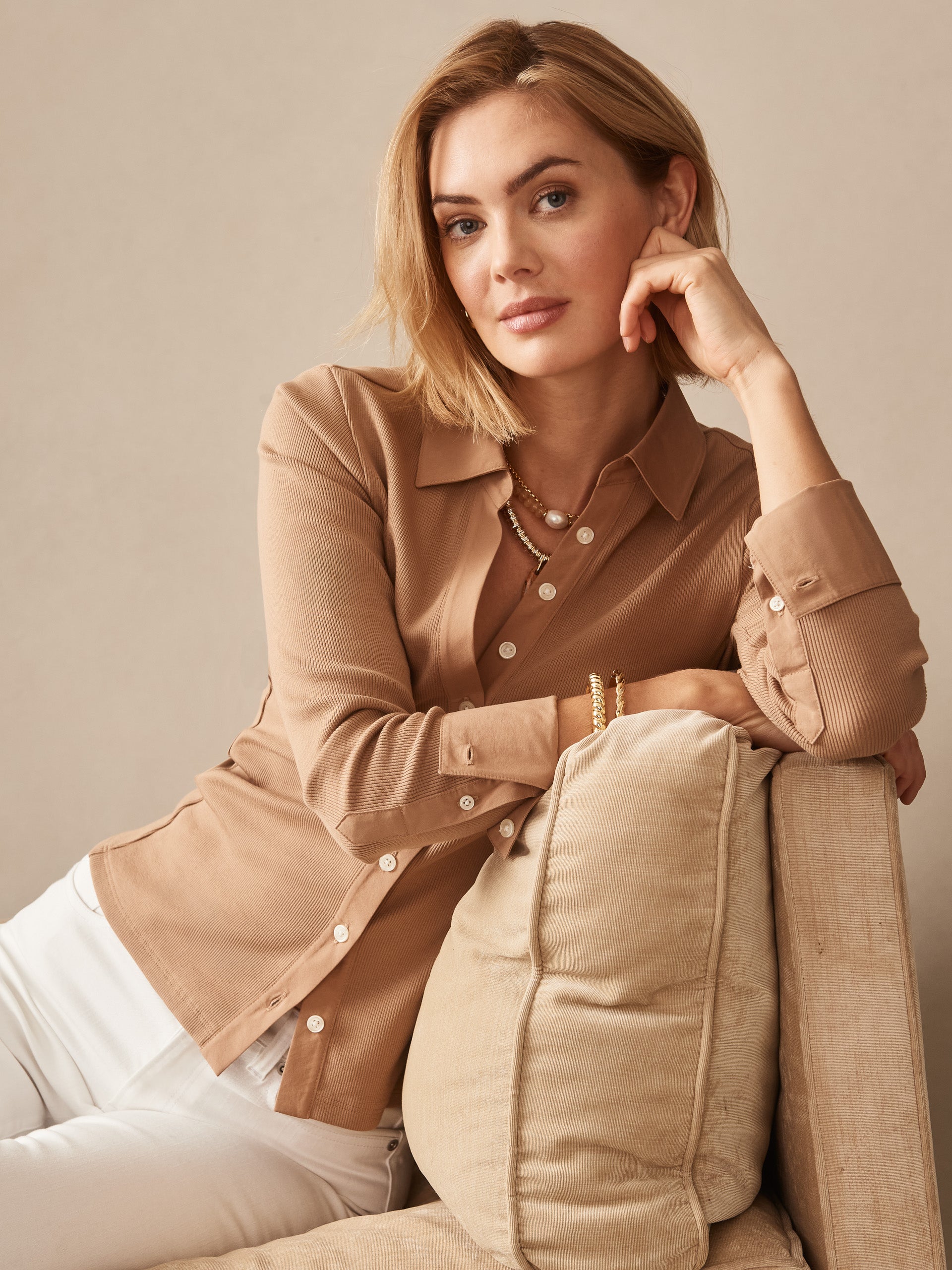 A woman wearing the Theodora Shirt in warm cinnamon tones by J.McLaughlin, showcasing effortlessly stylish design and enduring craftsmanship, embodying a legacy of timeless fashion.