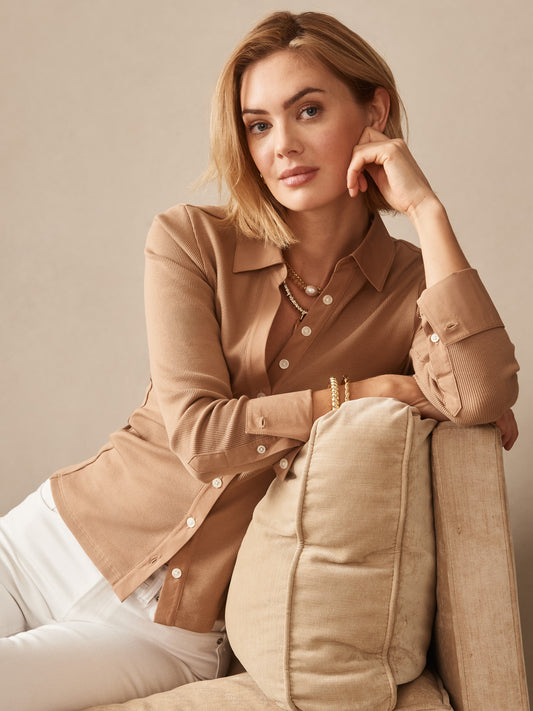 A woman wearing the Theodora Shirt in warm cinnamon tones by J.McLaughlin, showcasing effortlessly stylish design and enduring craftsmanship, embodying a legacy of timeless fashion.