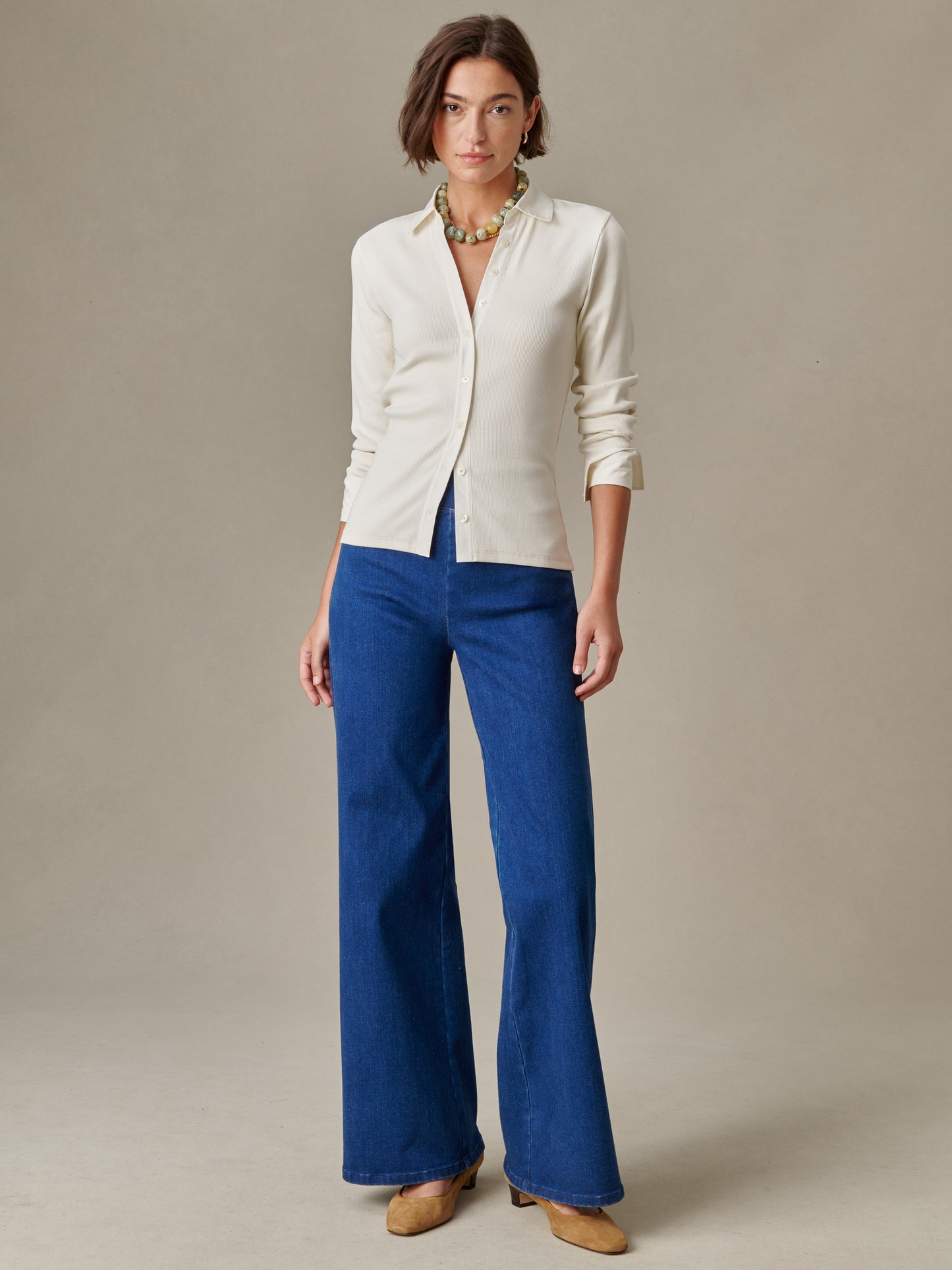 Woman wearing Theodora Shirt by J.McLaughlin in a timeless, effortlessly stylish design paired with high-quality blue wide-leg pants and tan shoes, embodying enduring elegance.
