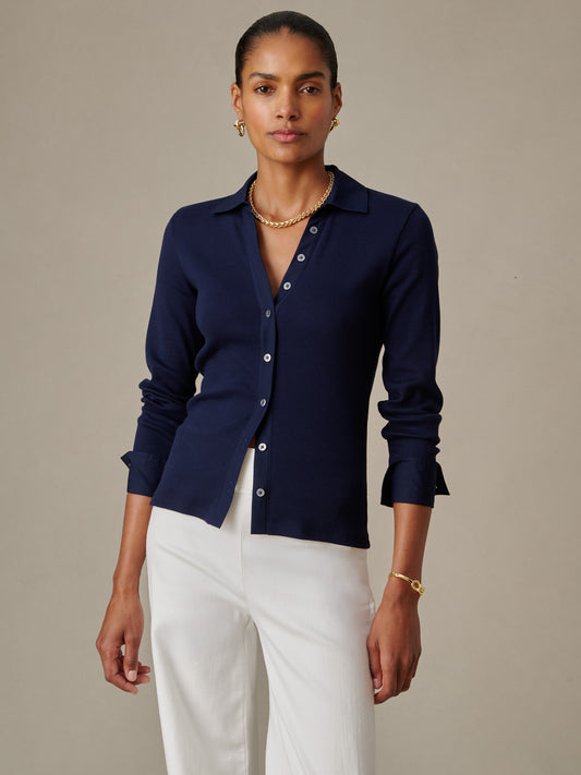 Woman wearing a navy blue Theodora Shirt by J.McLaughlin paired with white pants, showcasing an effortlessly stylish, timeless design perfect for refined, enduring fashion.