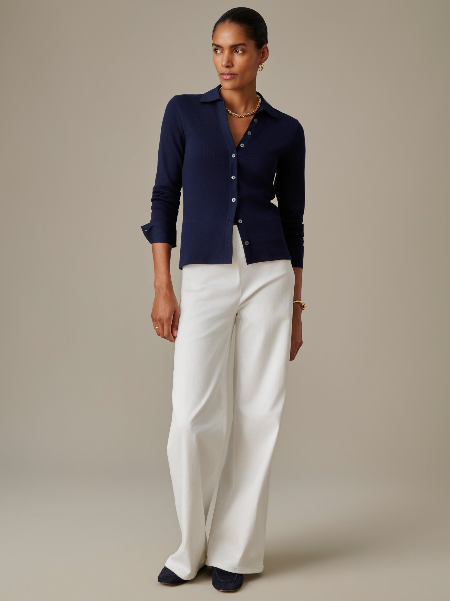 Model wearing Theodora Shirt by J.McLaughlin, a navy button-up shirt paired with wide-leg white pants, showcasing effortlessly stylish, enduring designs for a life well-lived.