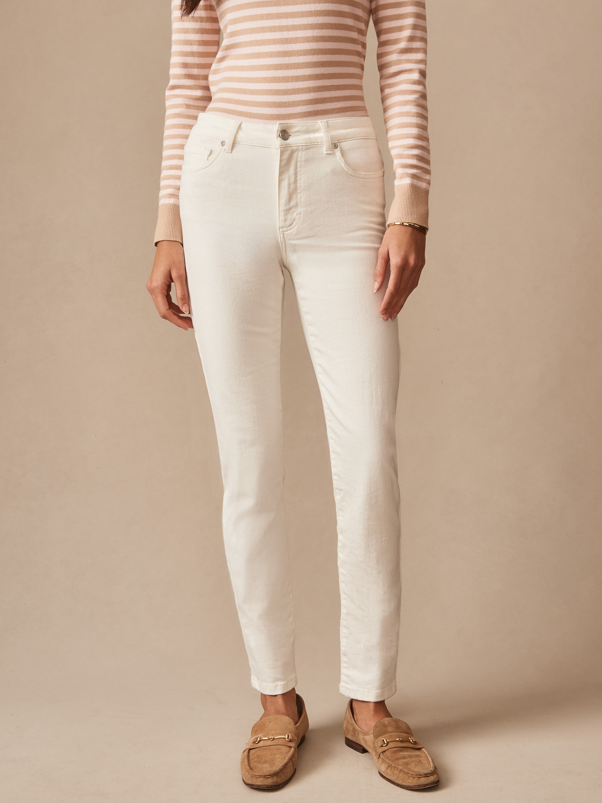Woman wearing cream-colored Watson Jeans by J.McLaughlin paired with a beige and white striped long-sleeve top and light brown loafers, showcasing timeless casual style.