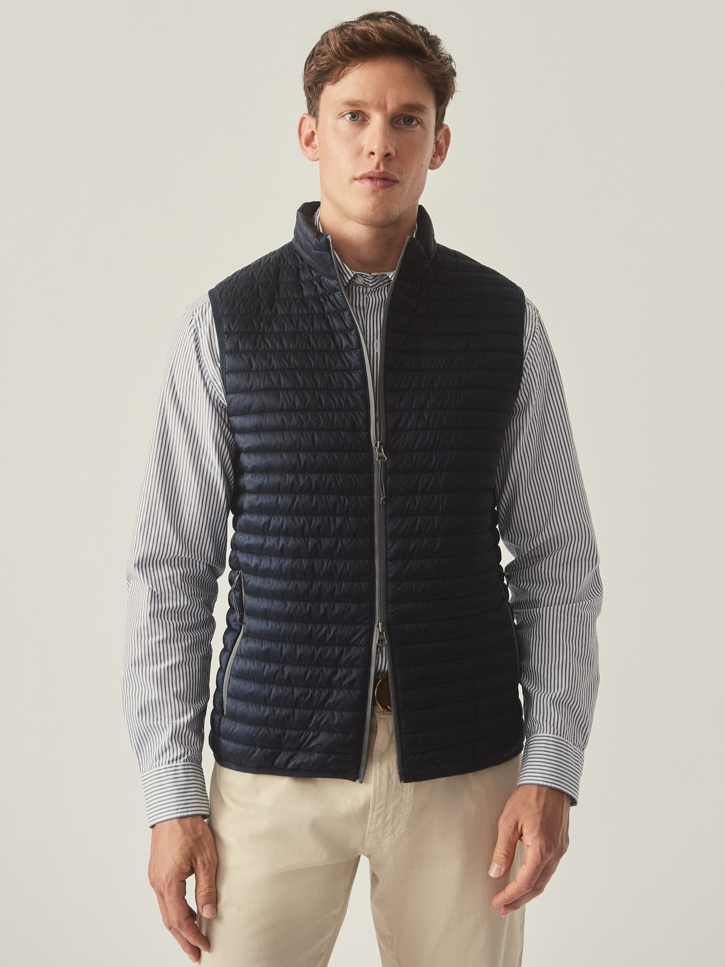 Model wearing J.McLaughlin Traveler vest in navy made with nylon.