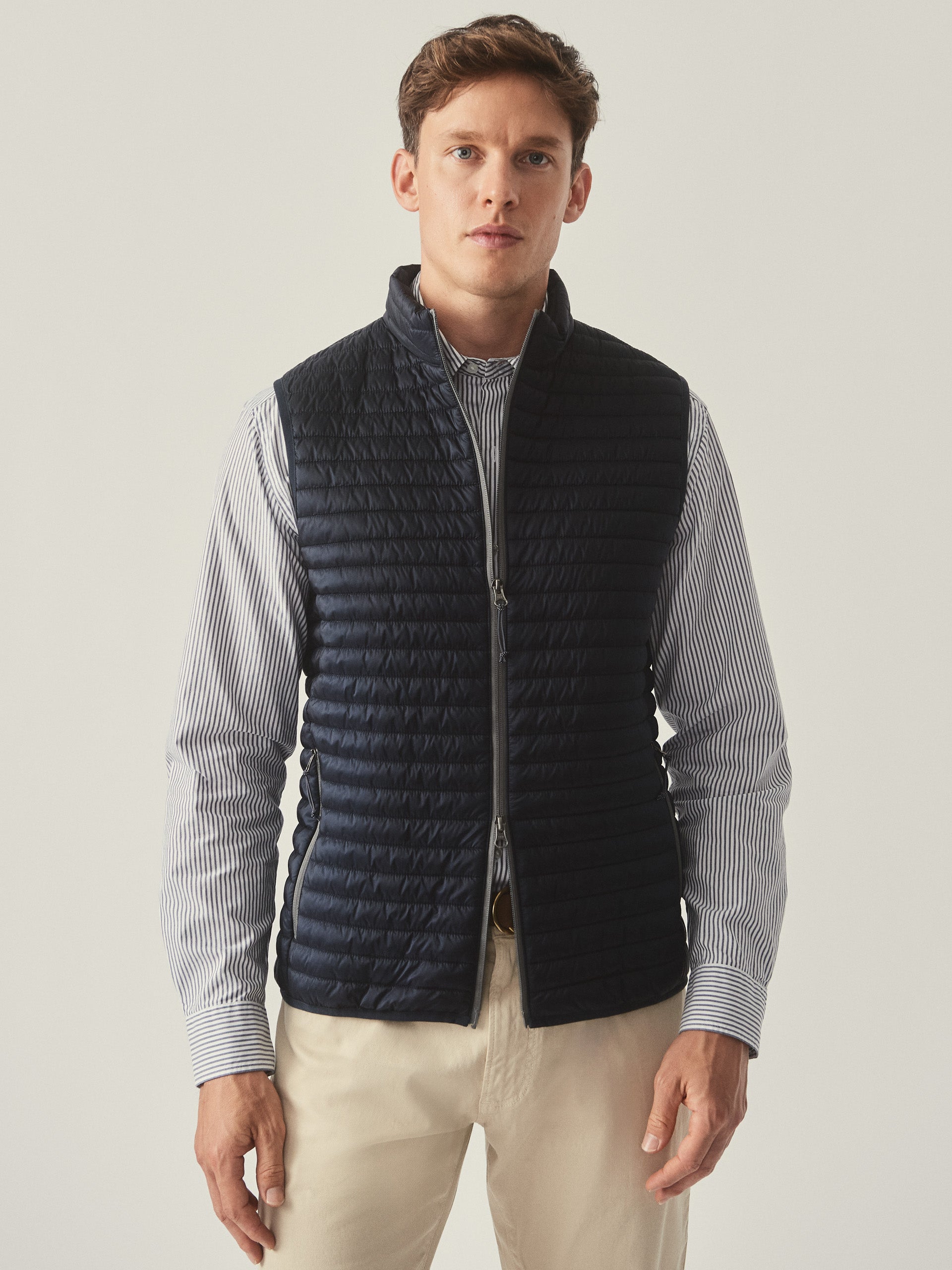 Model wearing J.McLaughlin Traveler vest in navy made with nylon.