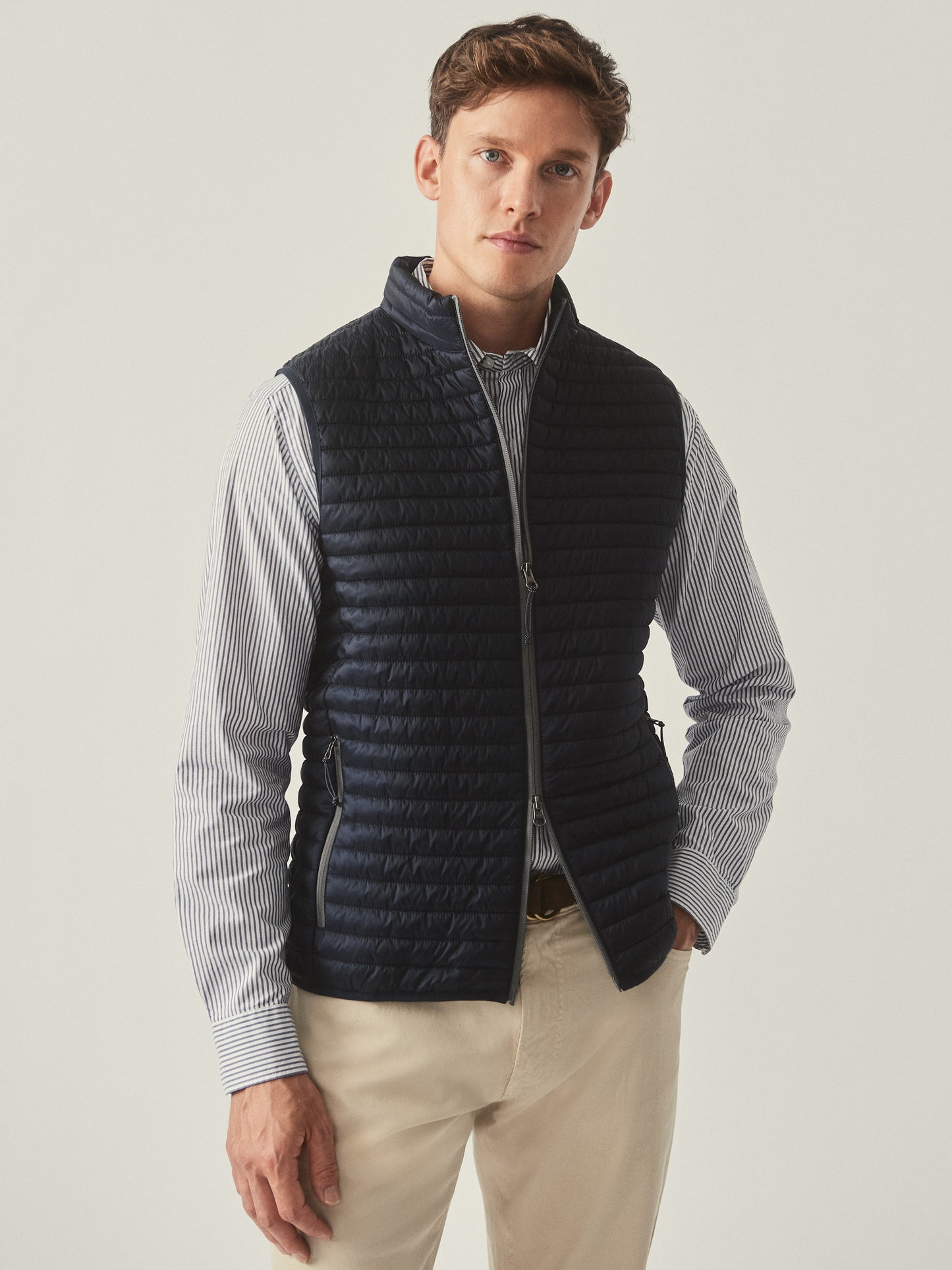 Model wearing J.McLaughlin Traveler vest in navy made with nylon.