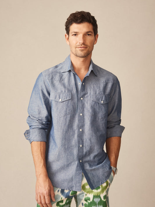 Man wearing a timeless Tribeca Western Shirt in soft navy blue by J.McLaughlin paired with patterned pants, showcasing effortlessly stylish and enduring designs in innovative fabrics.