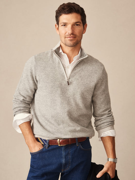 Man wearing a gray Twain Cashmere 1/4 Zip in Jacquard by J.McLaughlin, styled over a white shirt with jeans and a brown belt, showcasing effortlessly stylish, enduring designs.