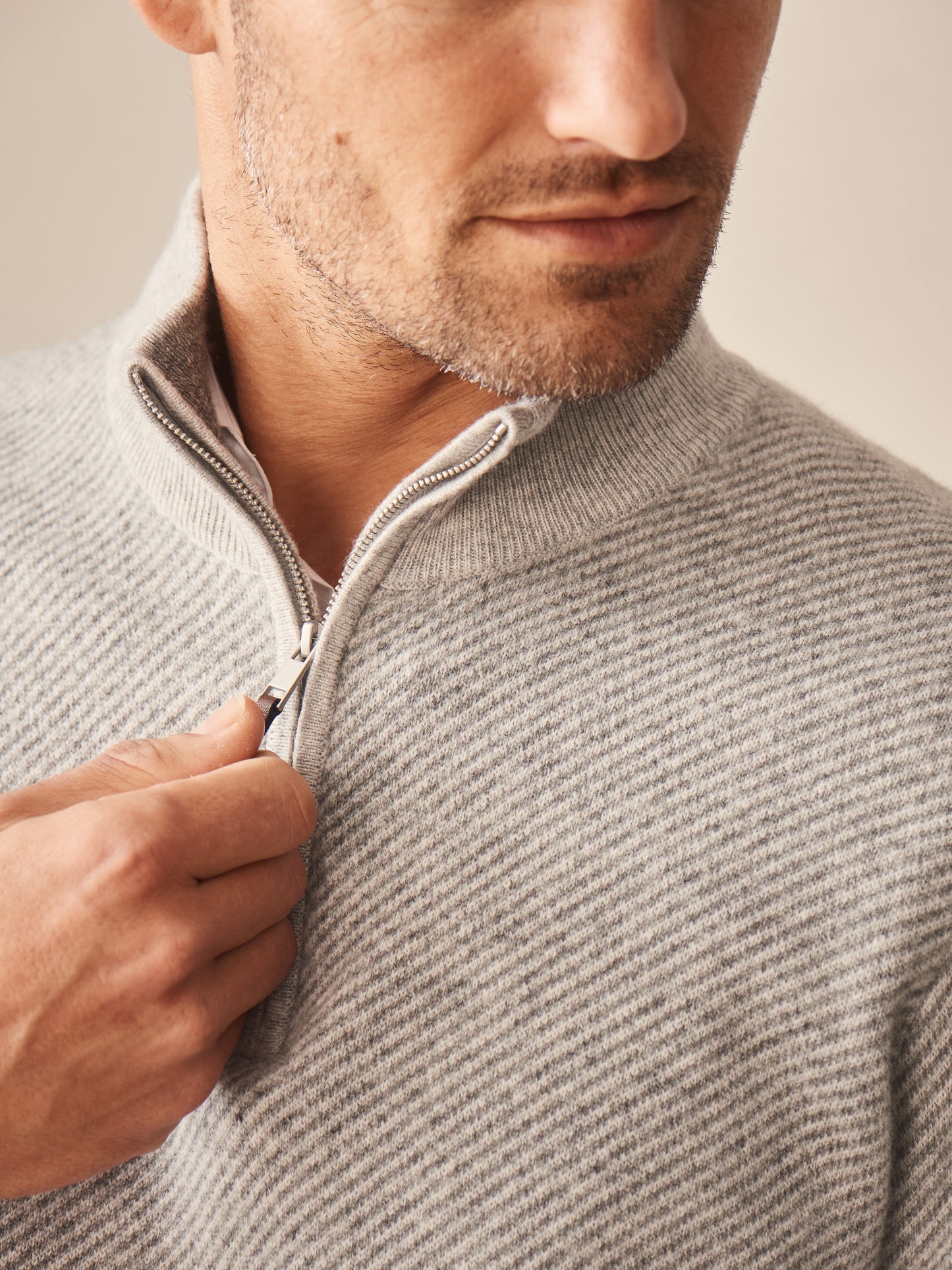 Close-up of a man wearing the Twain Cashmere 1/4 Zip in Jacquard by J.McLaughlin, showcasing the soft, gray cashmere fabric and elegant quarter-zip design, embodying effortlessly stylish, enduring designs with innovative fabrics and a legacy of timeless fashion. A destination for defining style. Life, Well-Lived.