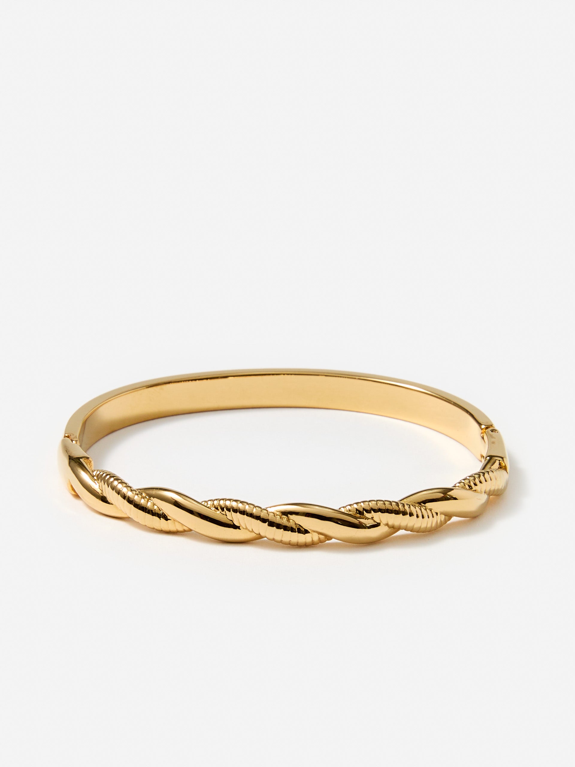J.McLaughlin twist hinge bangle in gold made with brass.