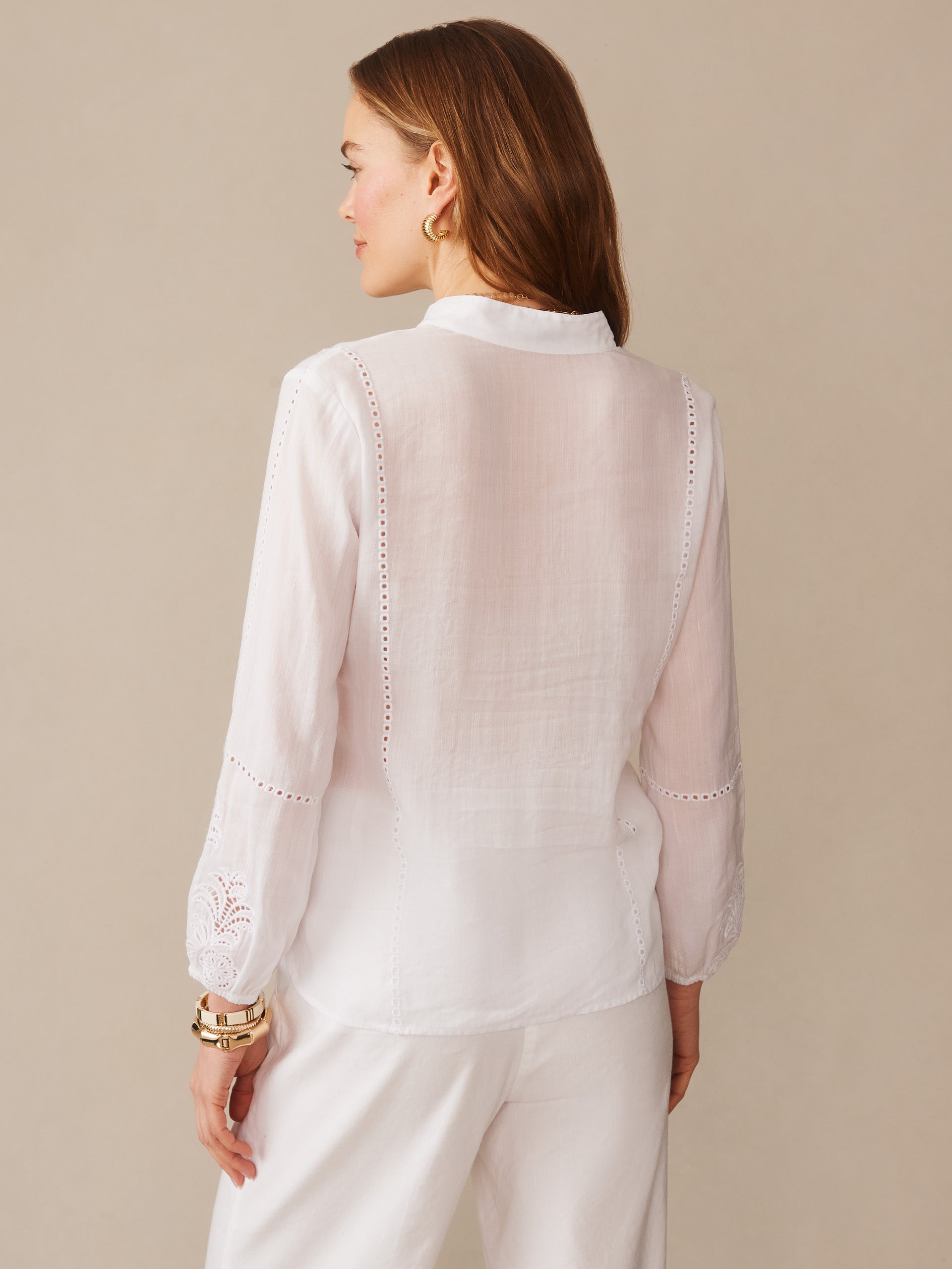 Back view of a woman wearing a white Varsha Blouse by J.McLaughlin, featuring delicate embroidery and lace details on the sleeves, embodying effortlessly stylish, enduring designs with a legacy of timeless fashion. A destination for defining style. Life, Well-Lived.