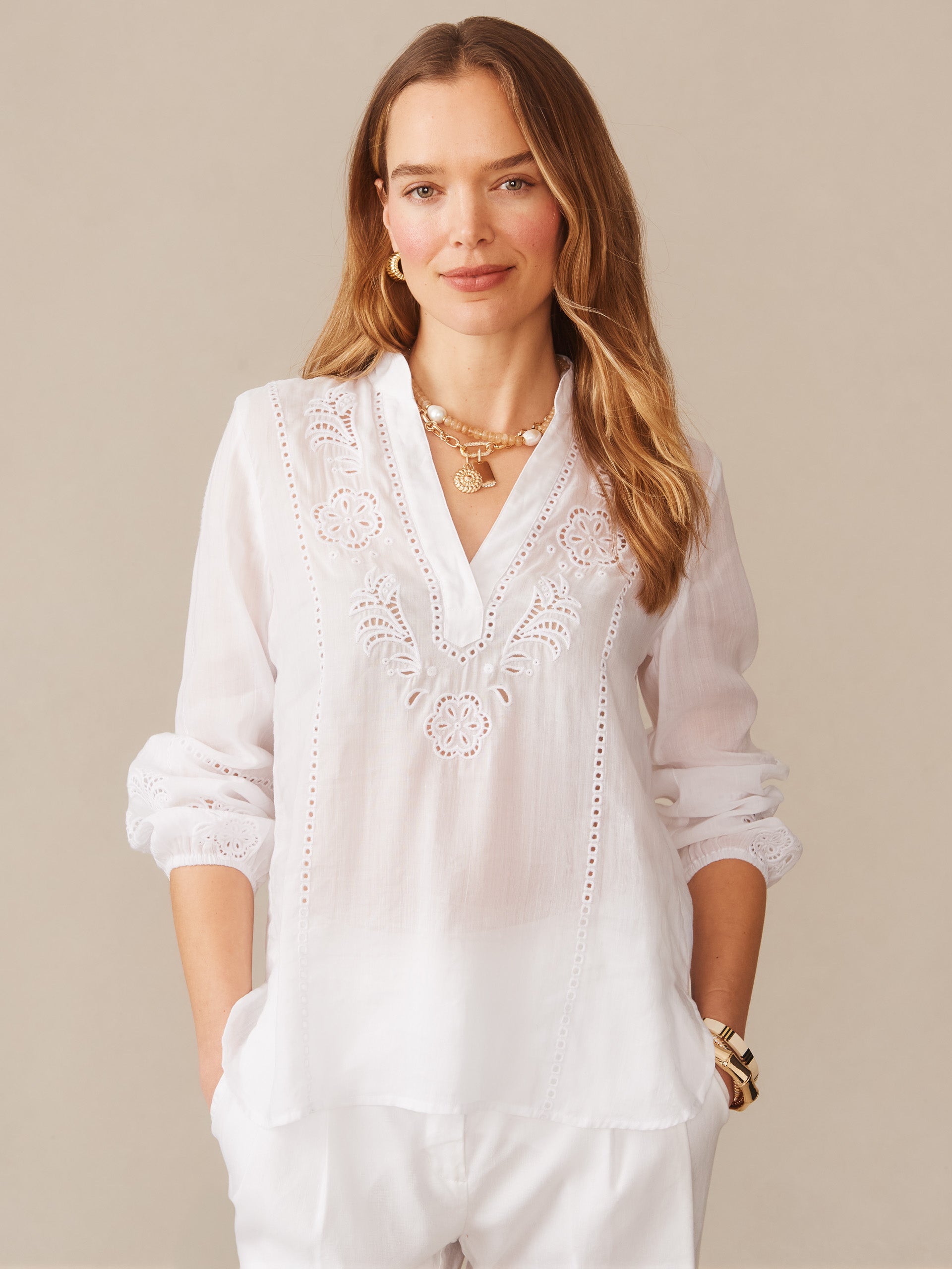 Woman wearing a white Varsha Blouse by J.McLaughlin featuring delicate embroidery and eyelet details, embodying effortlessly stylish, enduring designs with a legacy of timeless fashion. A destination for defining style. Life, Well-Lived.