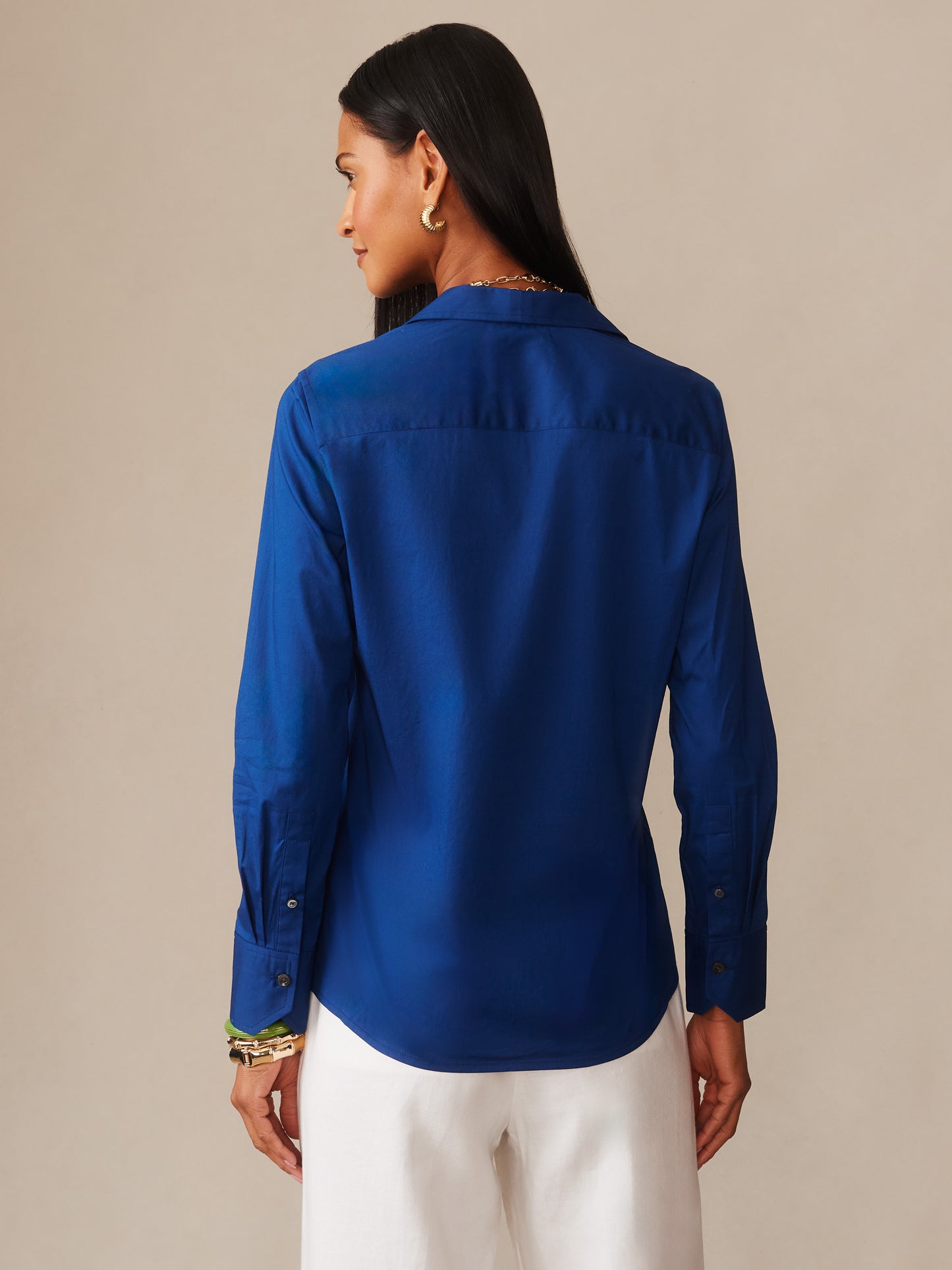 Woman wearing a navy blue Victoria Shirt by J.McLaughlin, showcasing effortlessly stylish, enduring designs with innovative fabrics in a classic, timeless fashion.