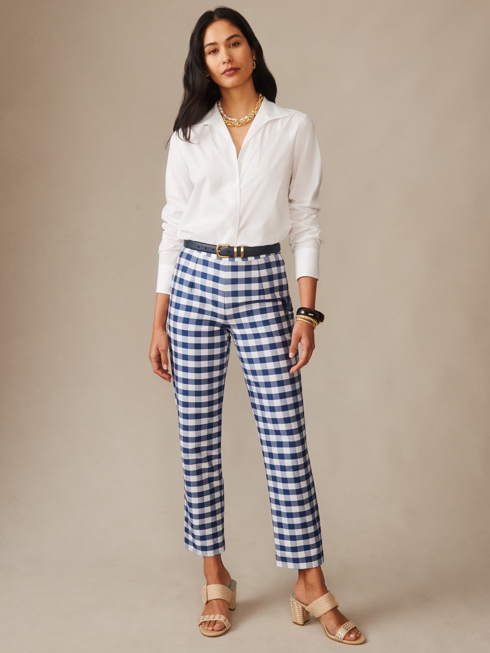 Woman wearing Millbrook Silk Blend Pants in Gingham paired with a white blouse and beige sandals, showcasing J.McLaughlin's effortlessly stylish, enduring designs with innovative fabrics.