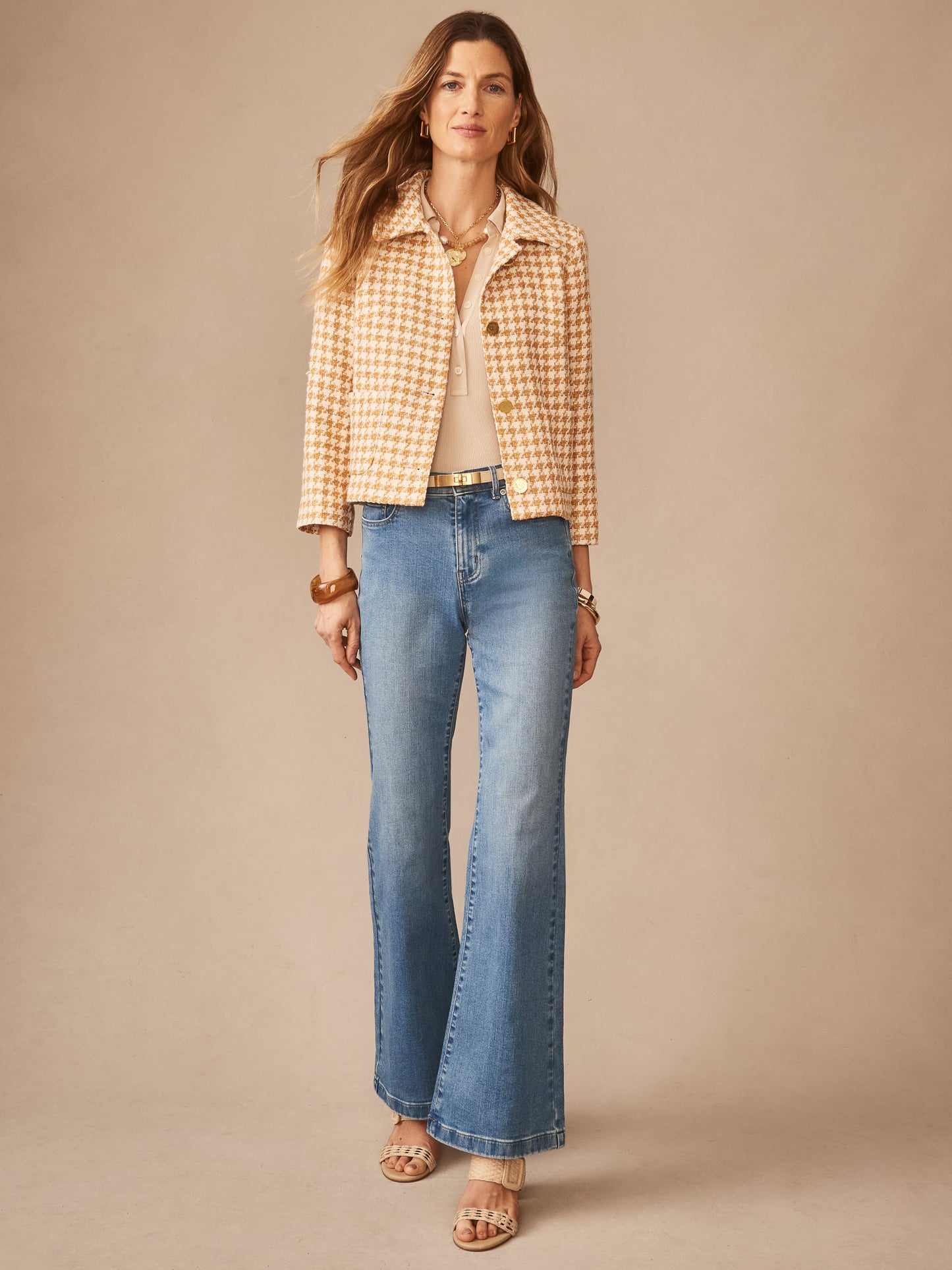 A confident woman wears the Violette Tweed Jacket in Houndstooth by J.McLaughlin paired with light wash jeans and neutral heels, showcasing effortlessly stylish, enduring designs in a legacy of timeless fashion. A destination for defining style. Life, Well-Lived.