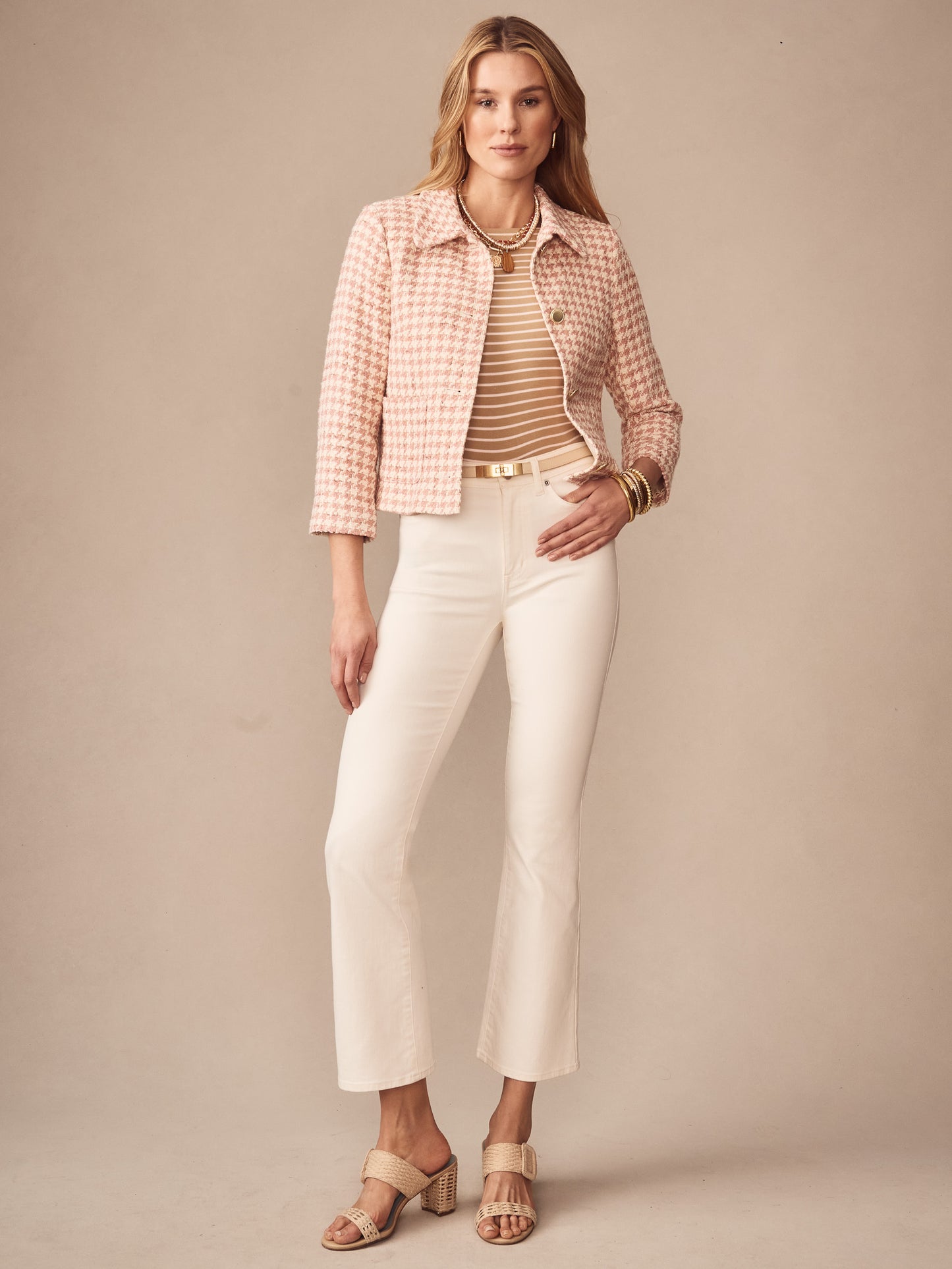 Model wearing the Violette Tweed Jacket in Houndstooth by J.McLaughlin, paired with cream pants and striped top, showcasing effortlessly stylish, enduring designs and innovative fabrics.