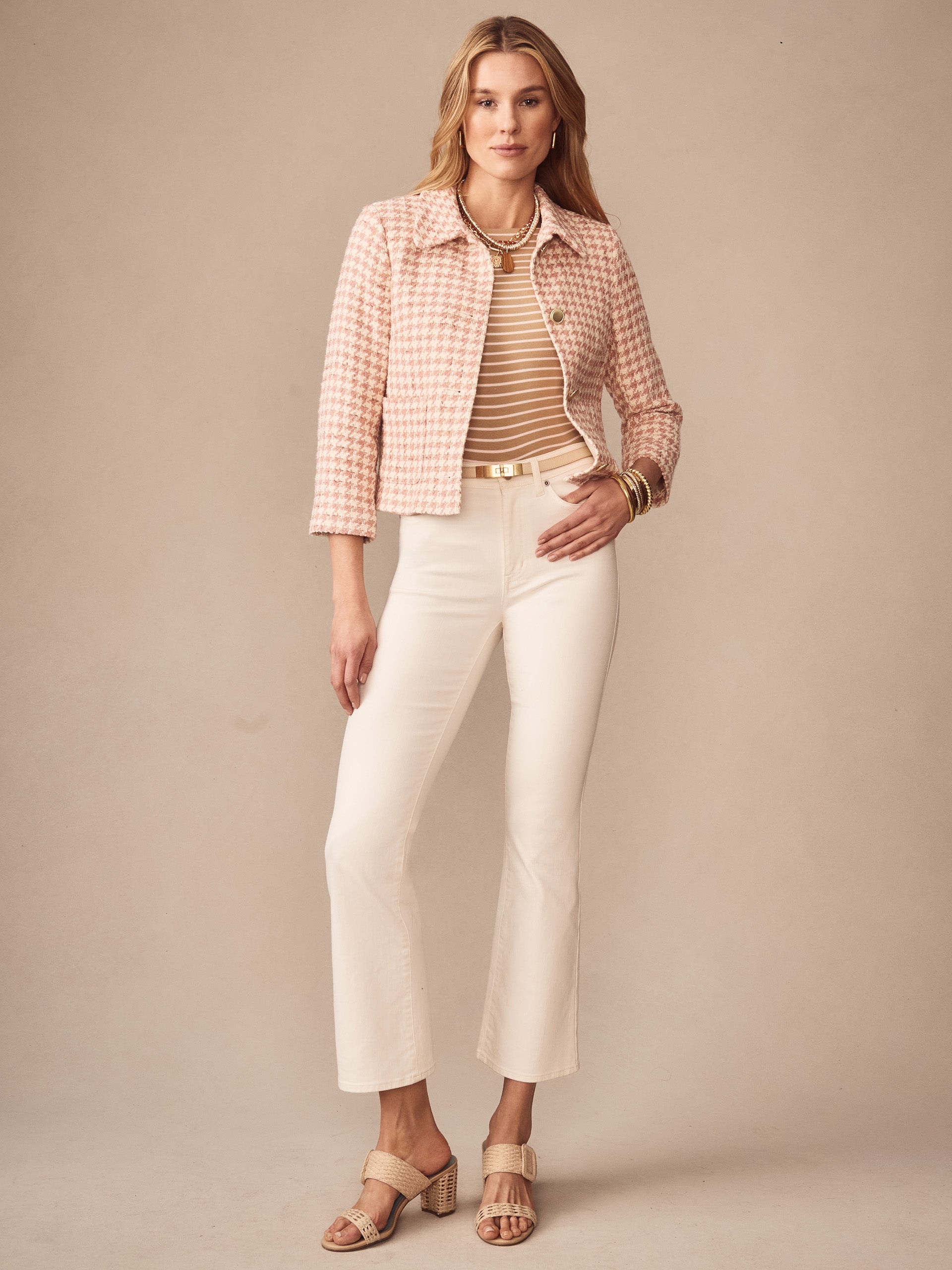 Model wearing the Violette Tweed Jacket in Houndstooth by J.McLaughlin, paired with cream pants and striped top, showcasing effortlessly stylish, enduring designs and innovative fabrics.